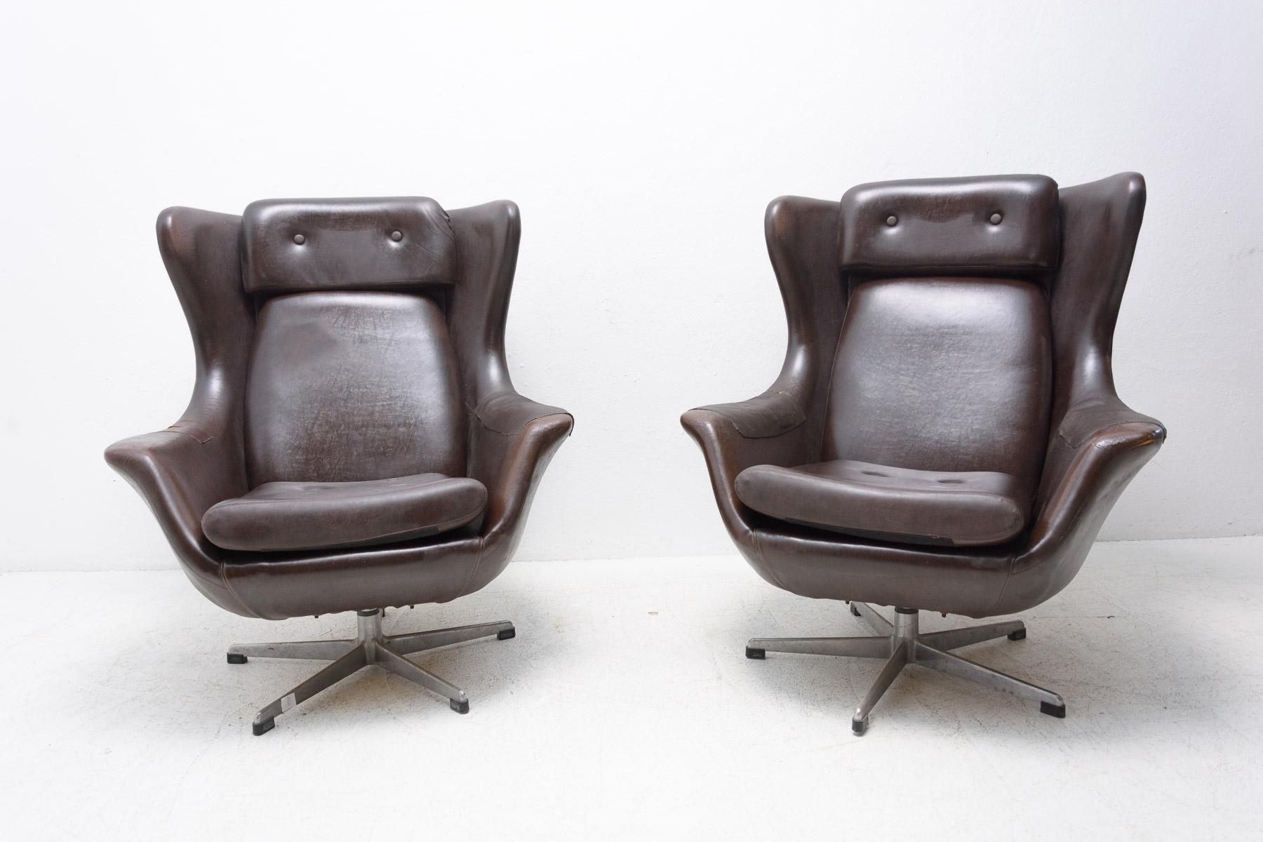 Pair of swivel armchairs from the 1970s manufactured by UP Zavody in the former Czechoslovakia.
These iconic chairs have a slightly curved shaped design on an aluminum swivel base. They are upholstered in original black leather. The leather is