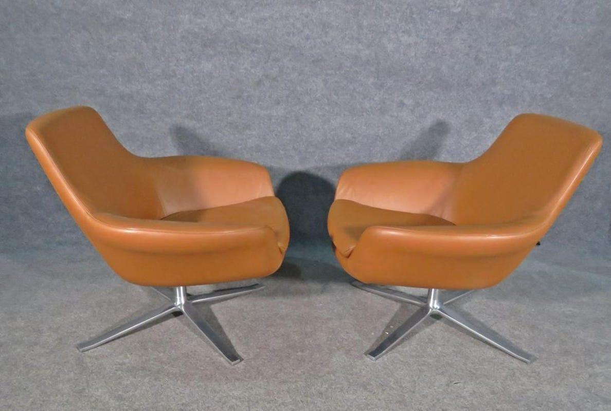 Pair of swivel chairs combining rich leather with a sleek and comfortable design, by Coalesse. This pair of chairs is perfect for an office or business setting. Please confirm item location with seller (NY/NJ).