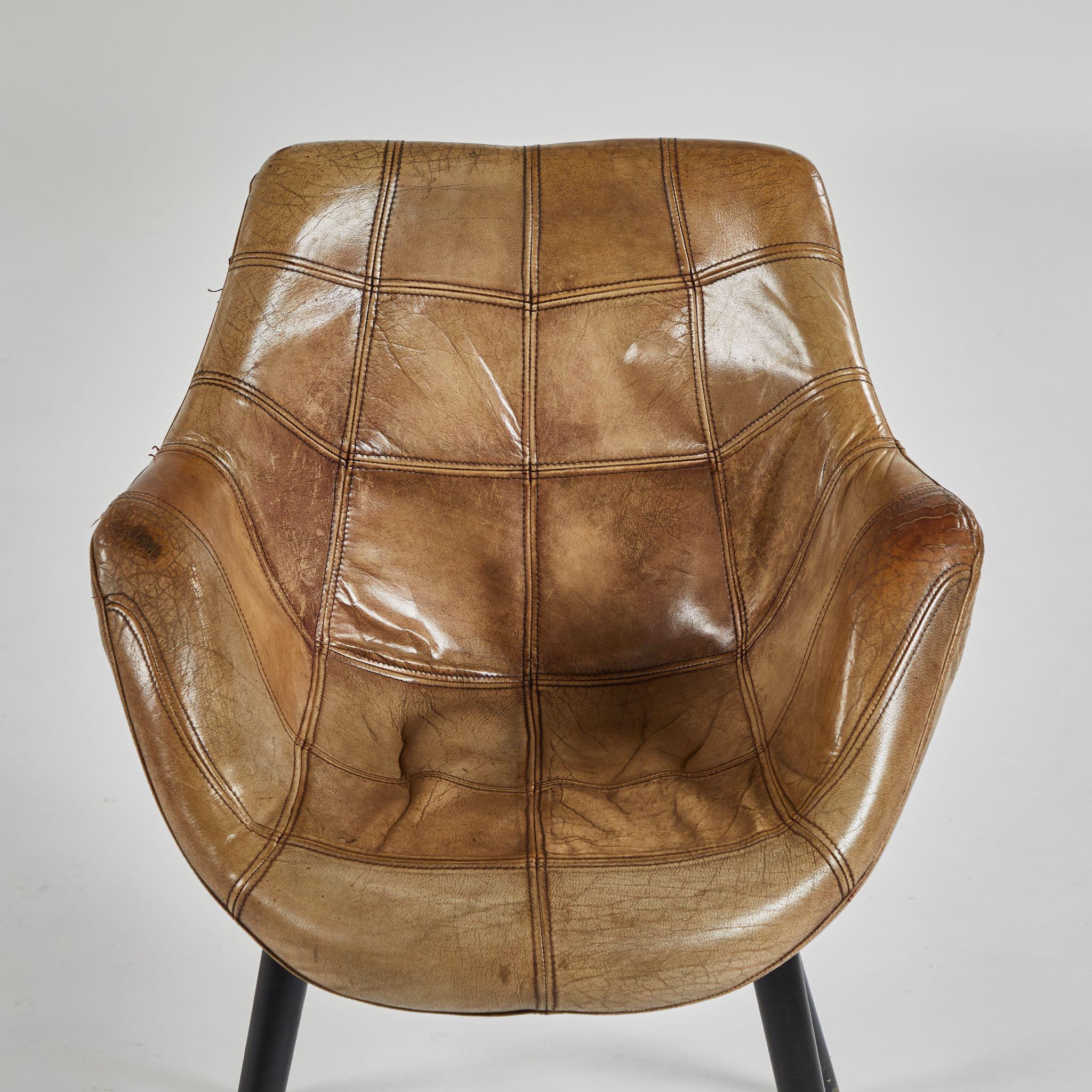 A pair of leather upholstered armchairs with seat, originating in France, circa 1969.