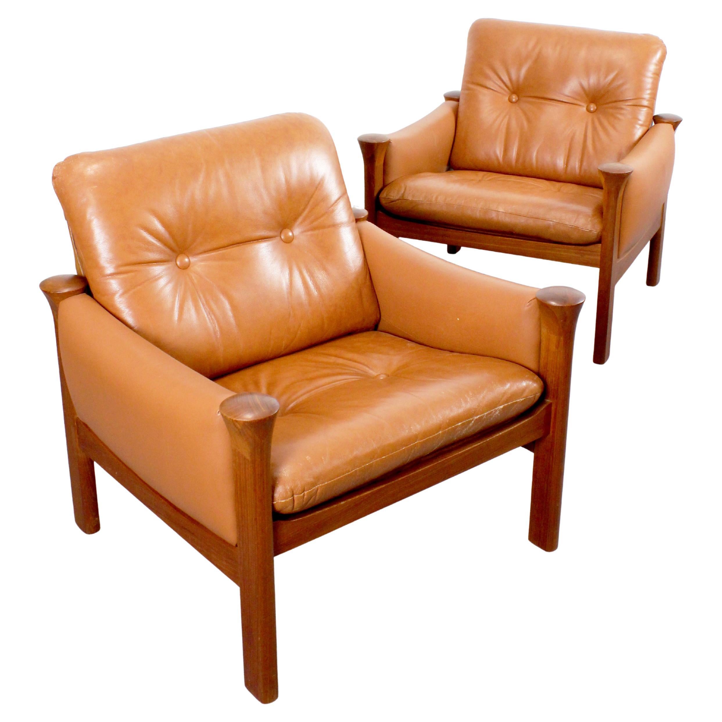 Pair of leather-upholstered armchairs with teak wood frames