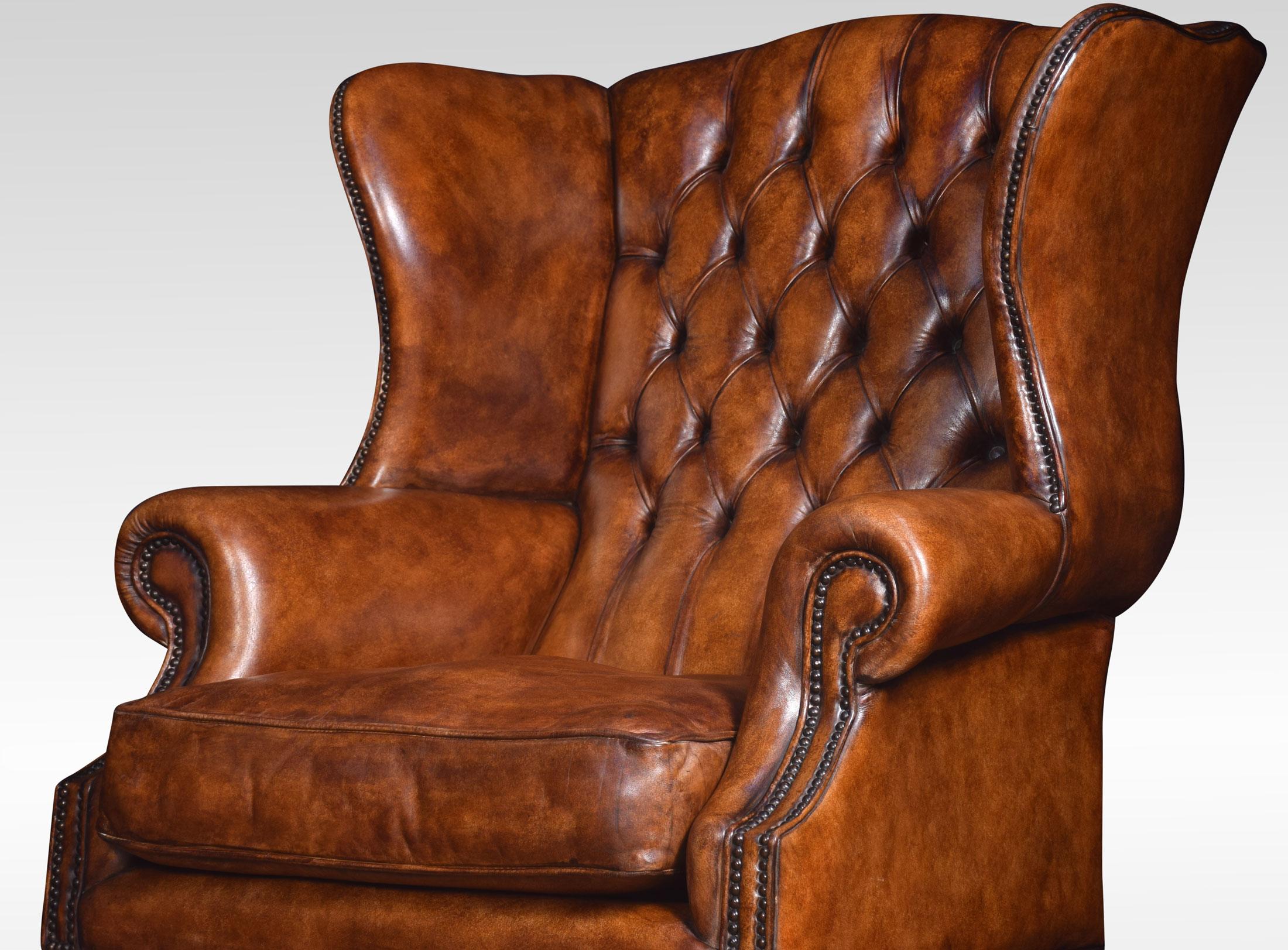 Pair of mahogany framed wing armchairs of generous proportions, the arched top above deep buttoned back, upholstered arms and seat in brown leather. All raised up on square supports united by a stretcher
Dimensions:
Height 49 inches height to seat