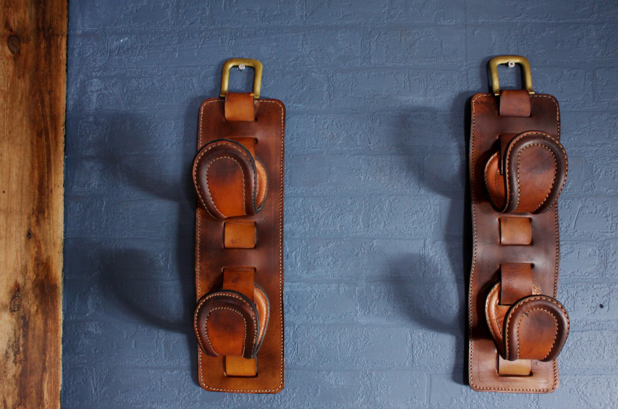 Pair of leather wine holders by Jacques Adnet, circa 1940.

A pair of two hook leather wine holders or gun rack by Jacques Adnet, a win bottle fits into the hooks, they are in thick saddlery hide leather with good stitch detailing and brass tops
