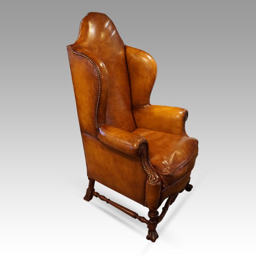 Pair of walnut leather wing chairs 
This pair of walnut leather wing chairs with the solid walnut underframe were made circa 1920.
This dramatic pair of wing chairs have the walnut legs that finish on Spanish feet, these are joined by a carved and