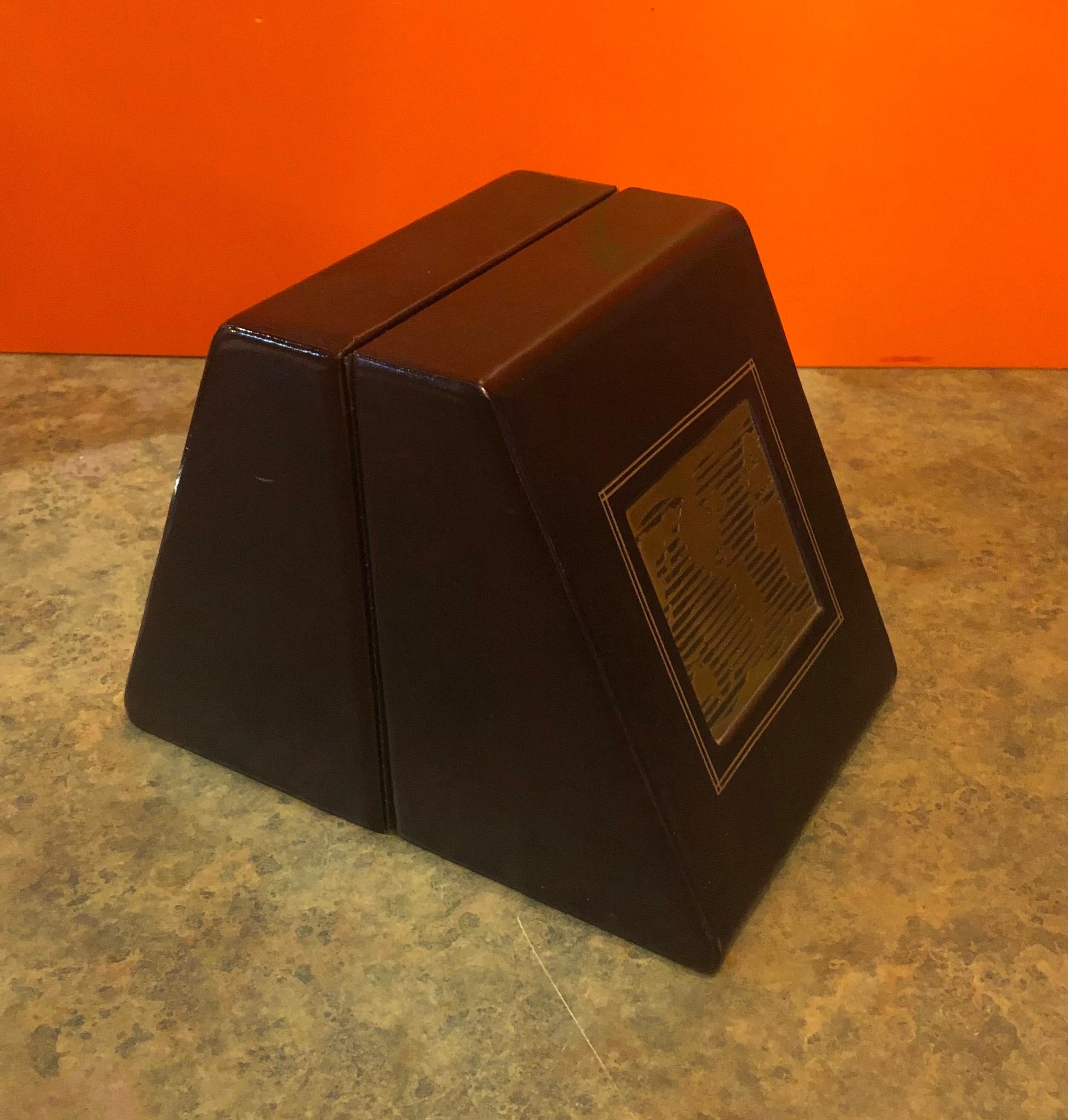 Classic pair of large leather wrapped bookends with a midcentury brass world map plaque embedded in the front, circa 1970s. The bookends measure 9