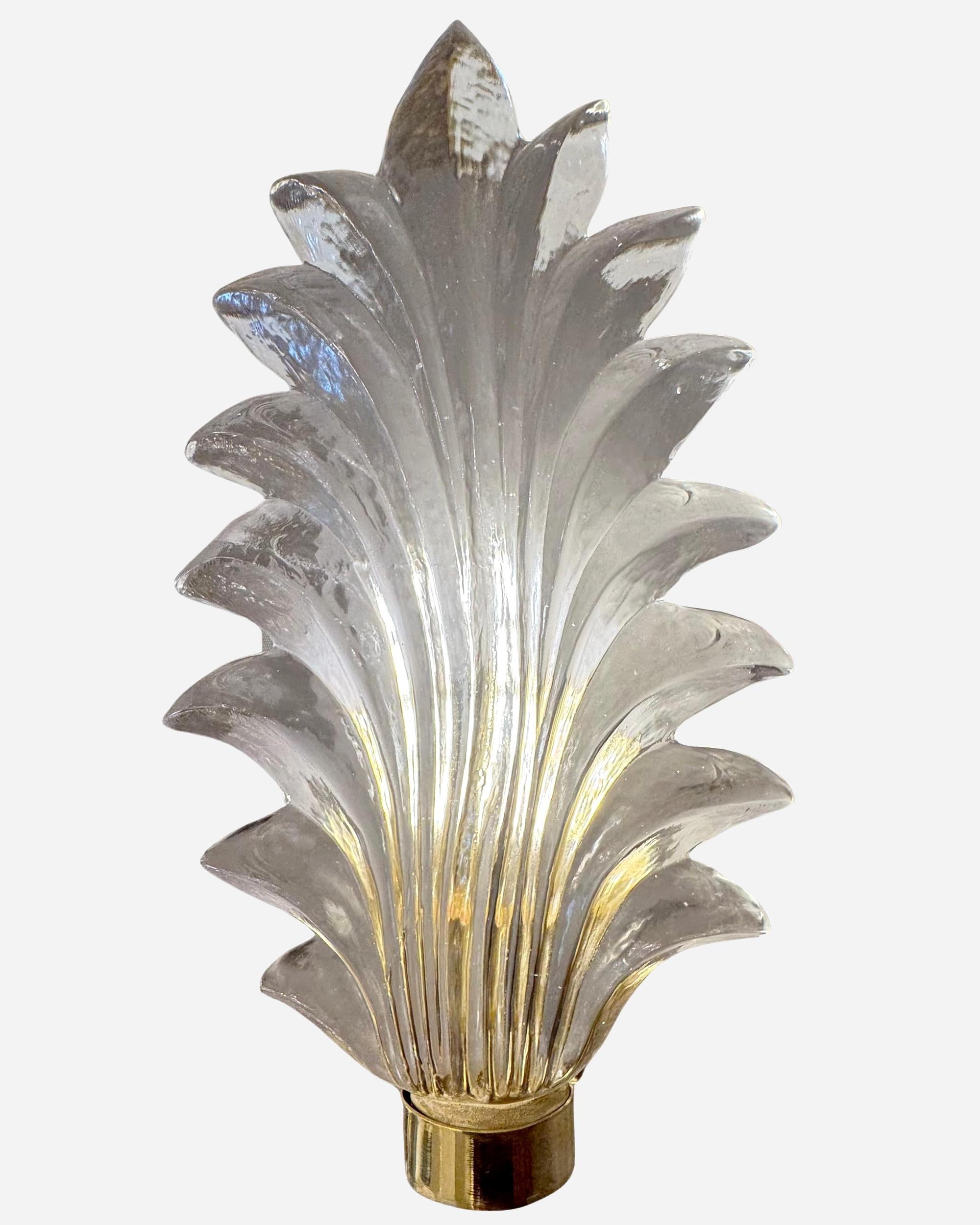 Appliques murales constituées d'une grande et épaisse feuille de verre de Murano, dépolie à l'arrière, dissimulant une ampoule.
Le support et la plaque de montage sont en laiton poli.
Deux paires disponibles.