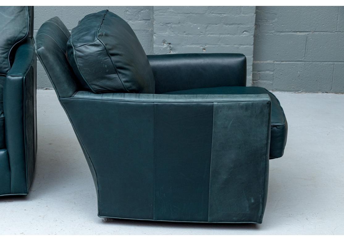 Fauteuils de salon pivotants en cuir vert Marin Elliot Marine avec dossier et coussin d'assise en vrac. Les chaises ont des accoudoirs carrés, des coutures passepoilées et sont bien proportionnées.

Dimensions : 30 1/2