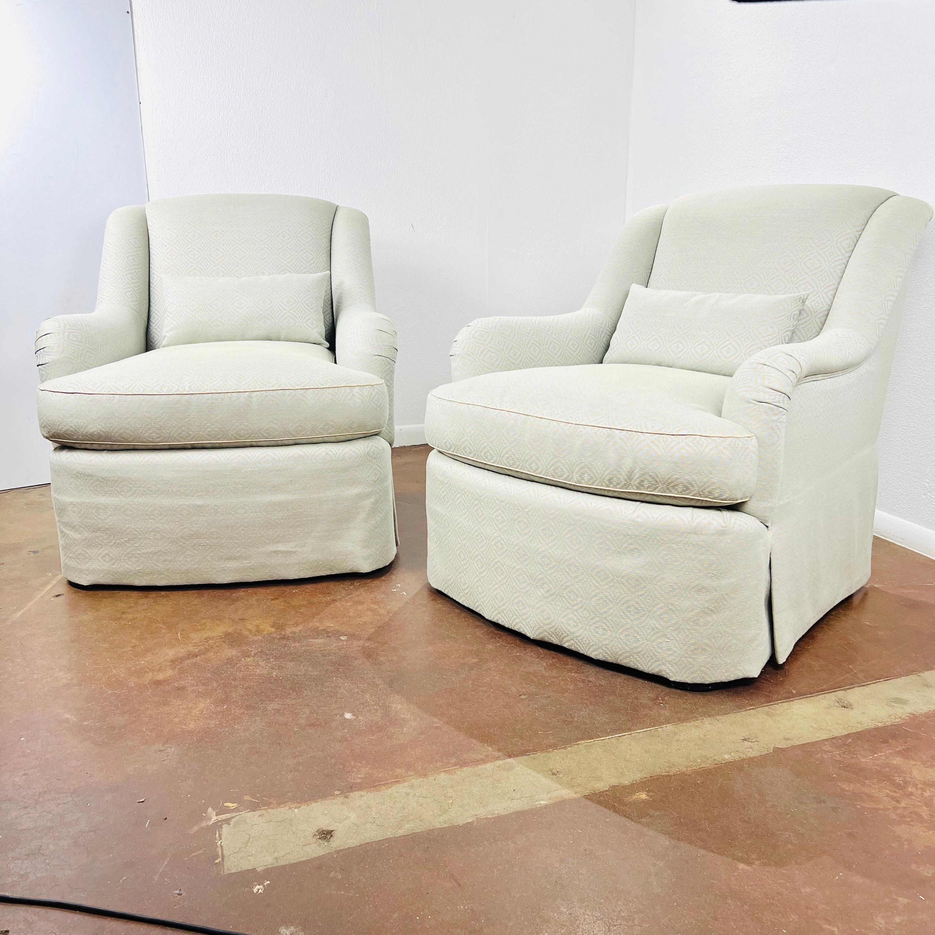 This elegant pair of English-arm club chairs features down wrapped T seat cushions and rests on tapered legs under a waterfall skirt. Upholstered in Lee Jofa fabric. Excellent condition with no rips, tears, or stains and very minimal signs of