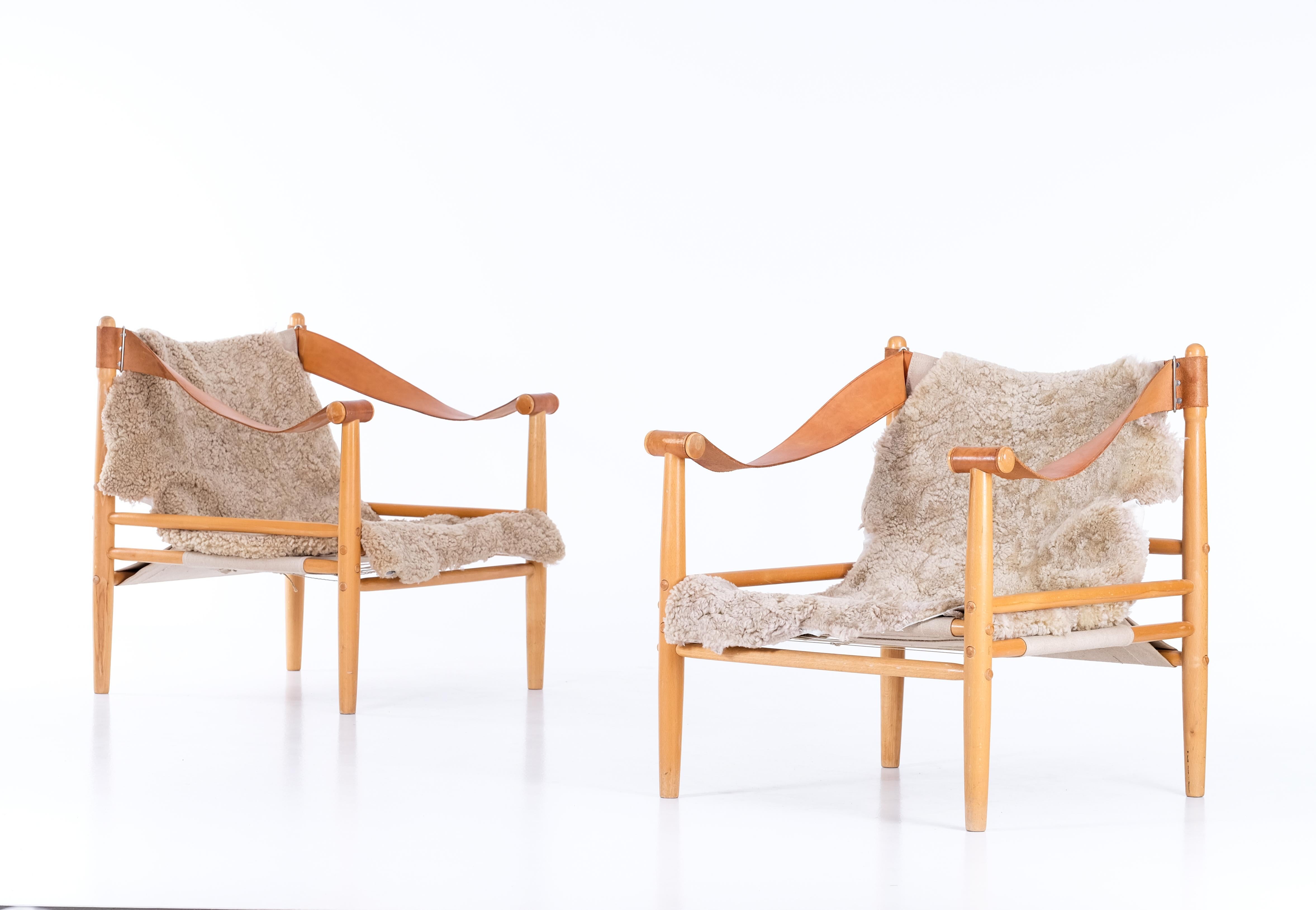 Pair of armchairs / safari chairs by Lennart Bender with leather, canvas, and new sheepskin. 
