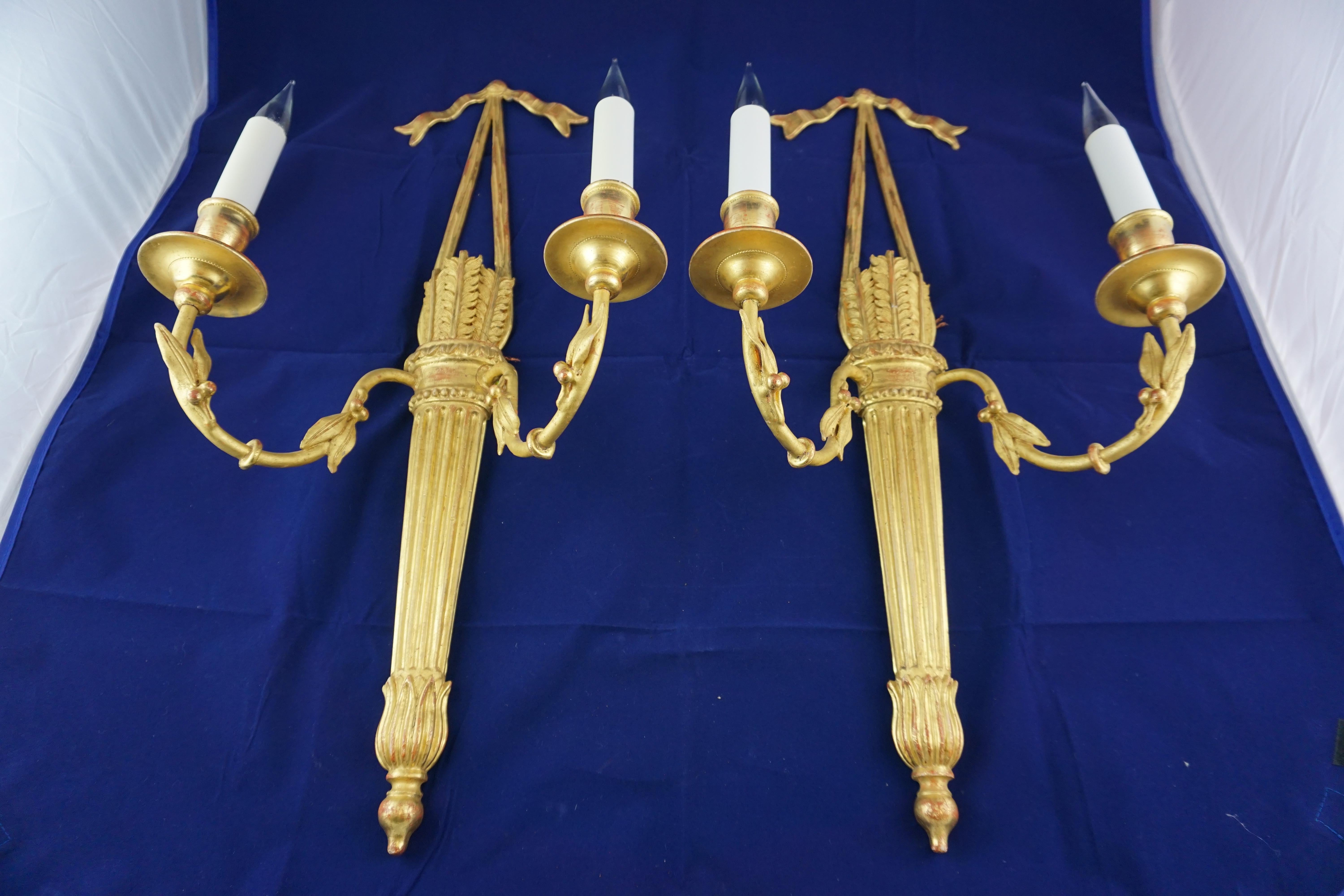 These handed, carved wood and gilded Louis XVI-style quiver wall lights with two lights, were made by the great firm of Leone Cei. Located in the heart of Florence, Italy since 1902, they work in ways that have not changed for over 500 years (except
