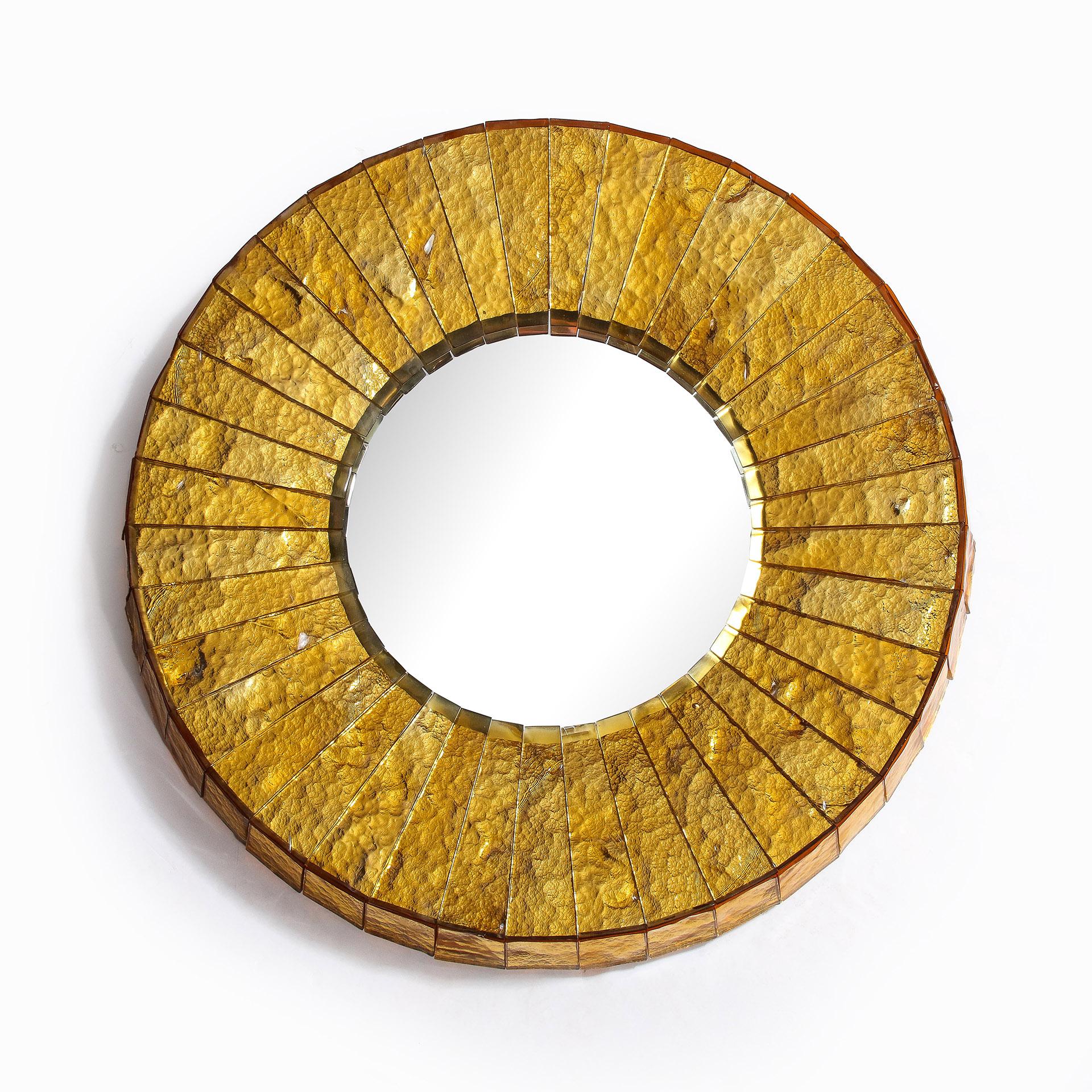 The round frame of hand-cut thick mirrored gold glass with chiseled sides of the same technique.