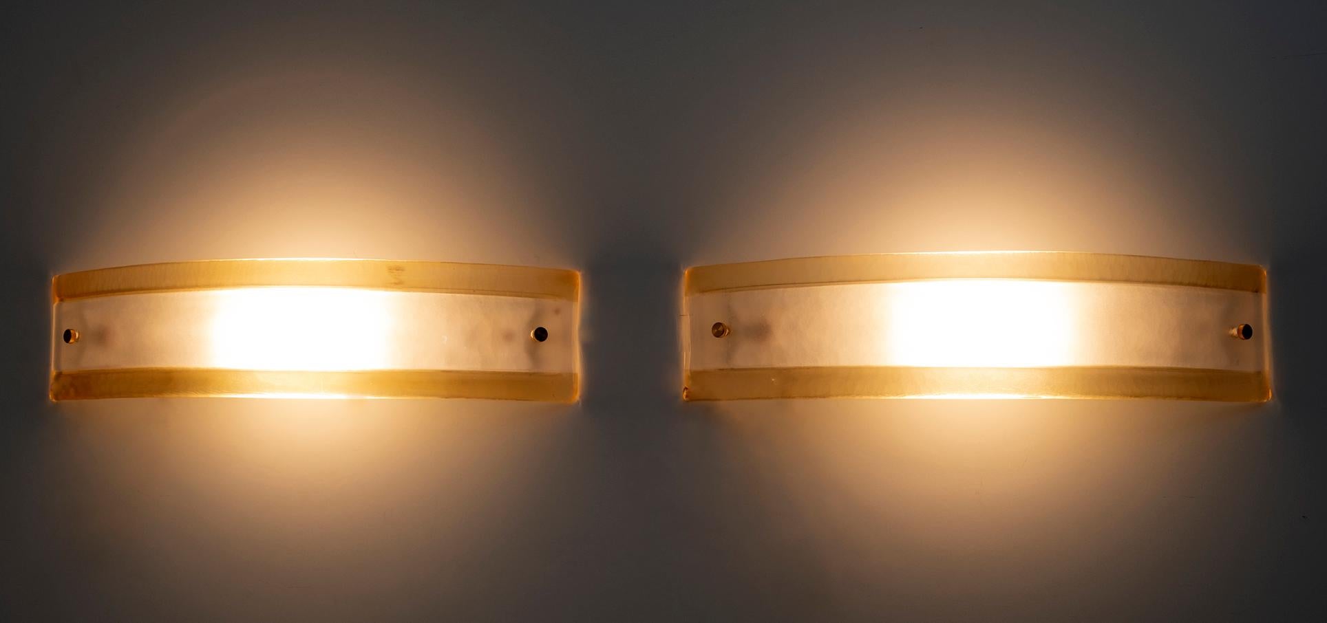 Pair of Leucos appliques in Murano glass with curved and satin glass diffuser in amber outside and white inside, 