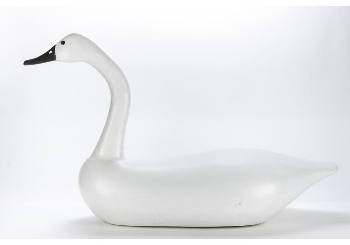 Una pareja grande e impresionante de cisnes tallados a mano, que en su día pudieron ser señuelos, de forma y presencia excelentes. En pintura blanca más reciente con pico y ojos negros. Los interiores sin pintar muestran claramente las marcas del