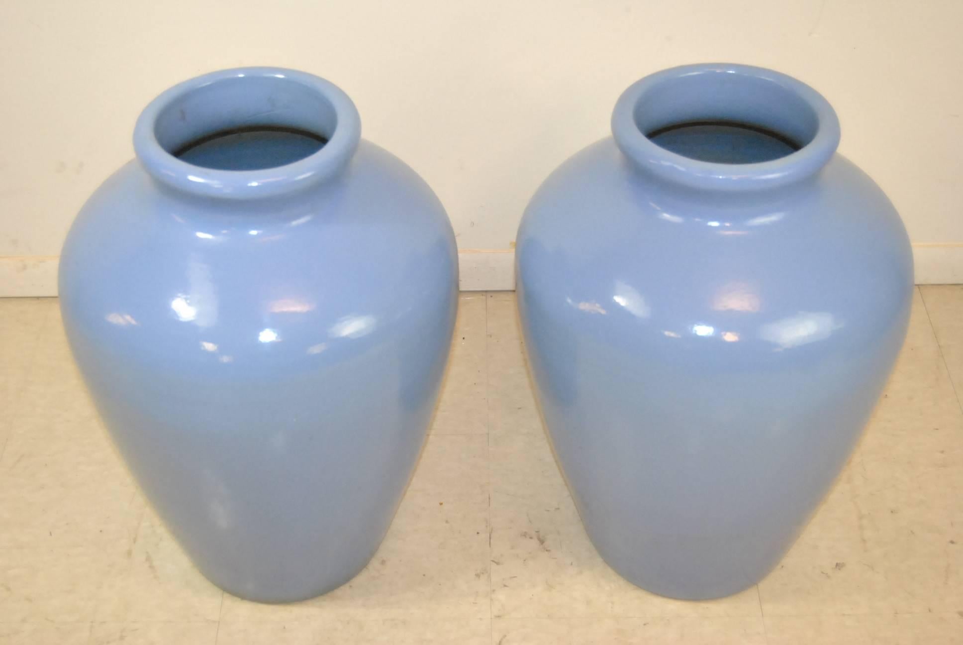 A beautiful pair of light blue ceramic floor vases. This pair of decorative vases looks just as pretty alone as it does with a bouquet of your favorite flowers. Perfect for home décor or outdoor fashion. Marked on the bottom USA and numbered. Very