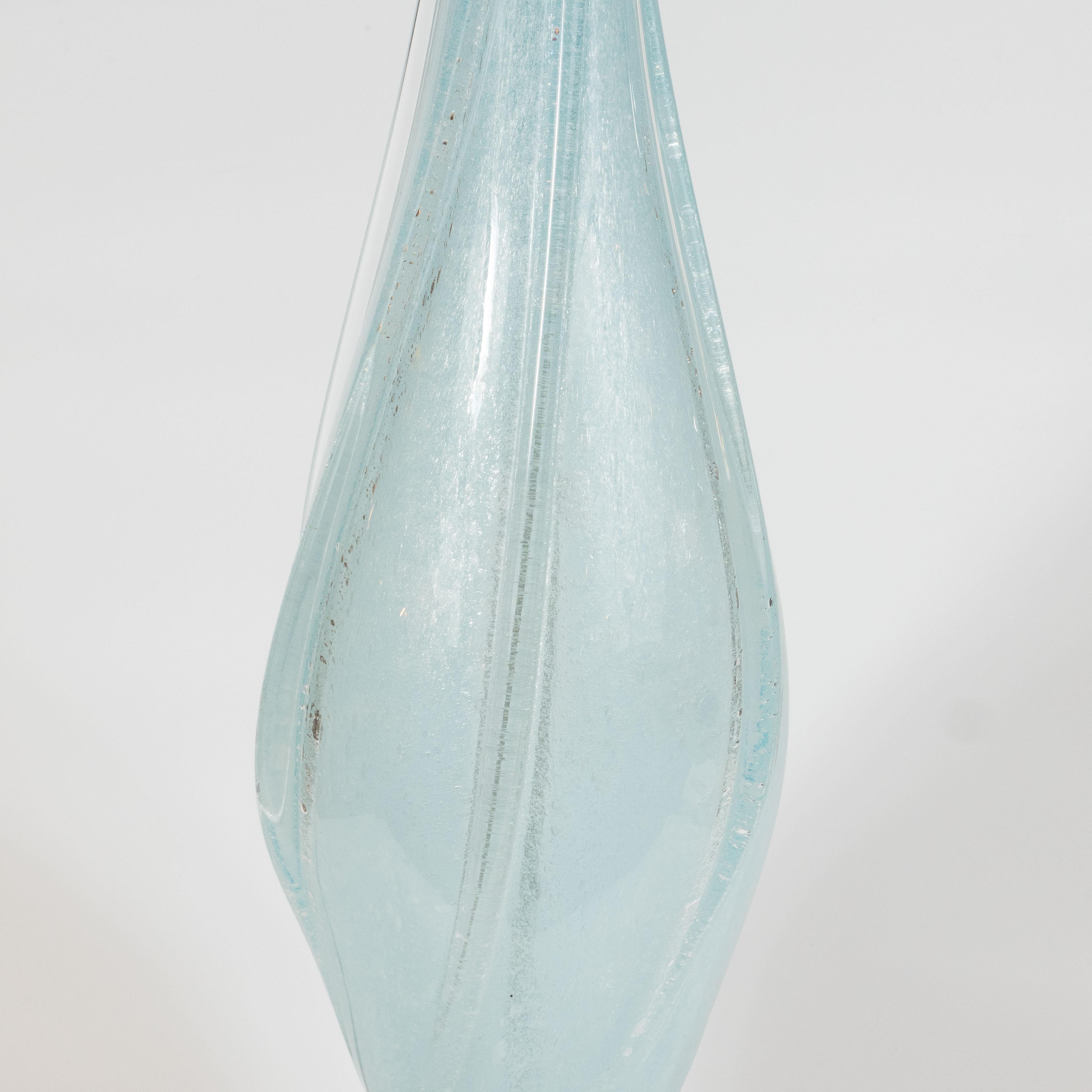 This stunning pair of Mid-Century Modern table lamps were hand blown in Murano, Italy- the island off the coast of Venice celebrated for centuries for its superlative glass production- by Seguso, one of the great makers of the era. The lamps offer a