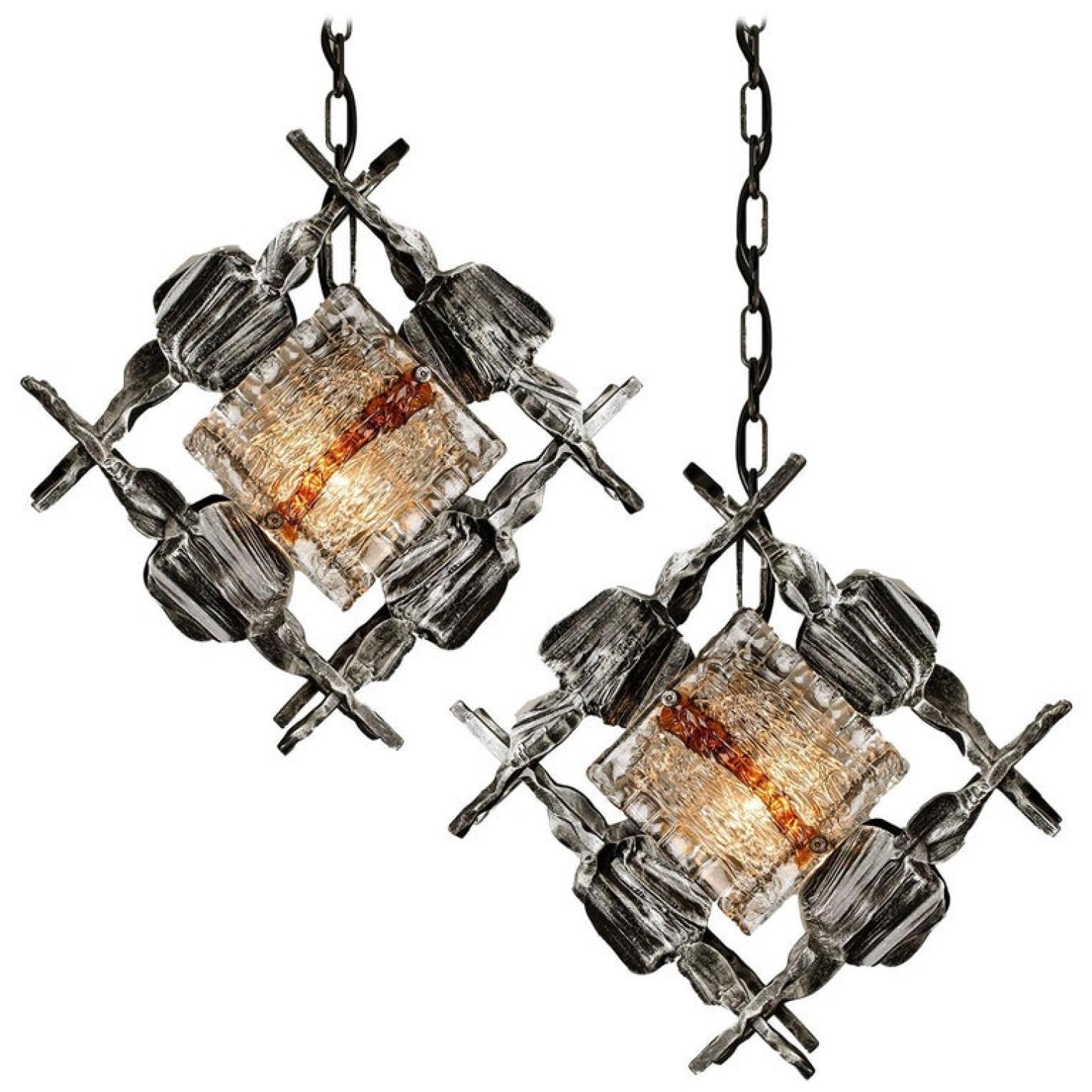 A set of Brutalist pedant light fixtures by Tom Ahlström & Hans Ehrlich, Sweden, 1960s,
A absolute strong and sculptural design!

The handwrought iron surround has a good patination and is set off by the Murano ice glass with its clear and amber