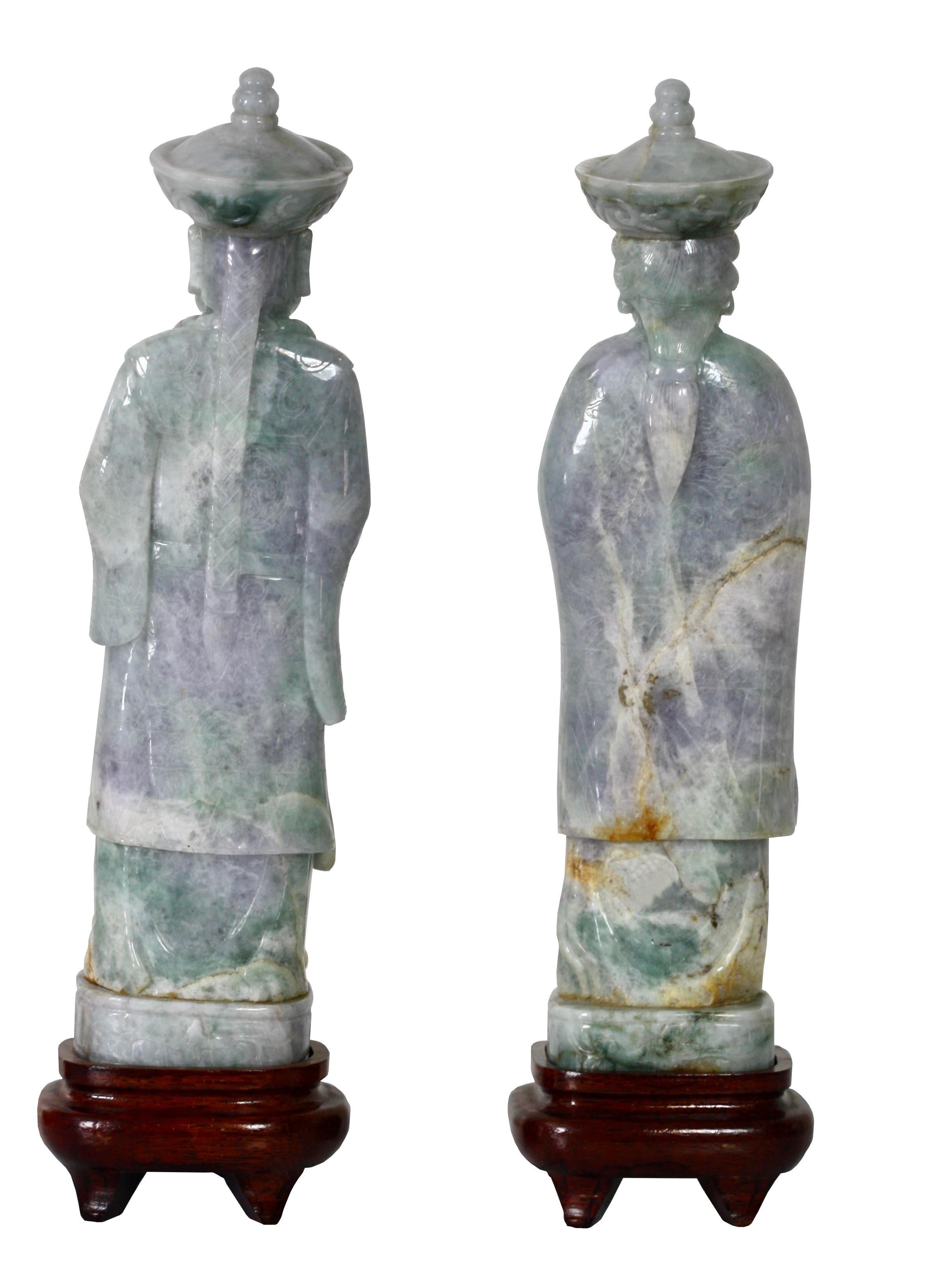 Pair of light lavender Jade Figures of a Queen and King 
20TH CENTURY
Carved as a standing queen dressed in lavish traditional attire and adorned with elaborate jewelry her face rendered with a gentle smile; and a figure of a king standing on a