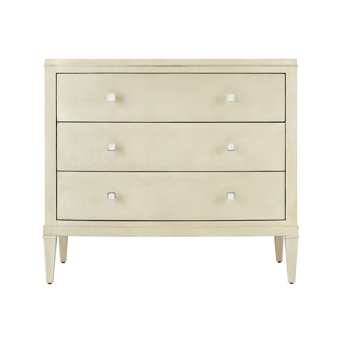Wrapped in a shagreen embossed leather in our light overcast dove finish, with three long drawers and with polished nickel finish hardware and trim, raised on square tapered legs with nickel collars.

Dimensions: 34