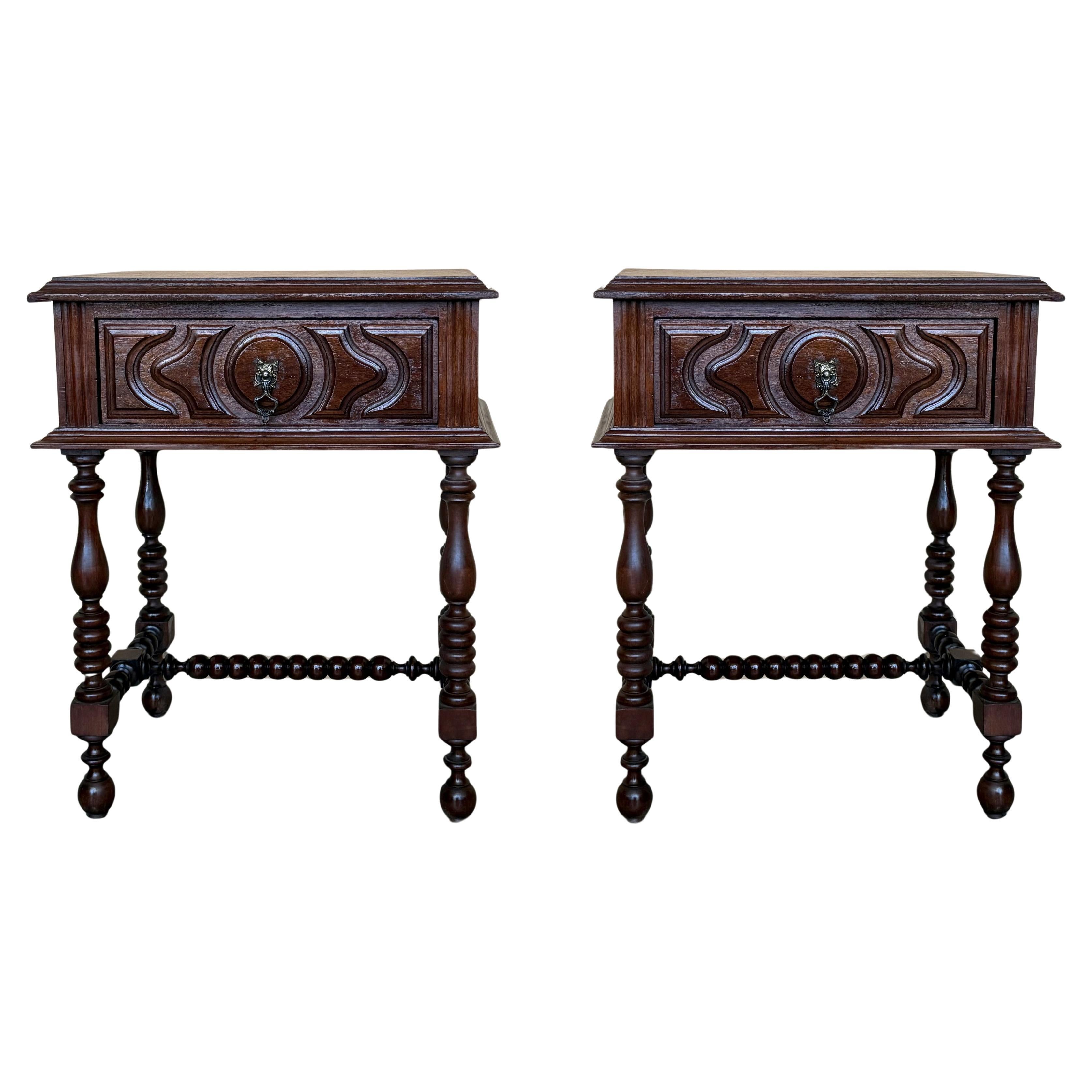 Coppia di comodini spagnoli intagliati in noce chiaro con gambe tornite e cassetto