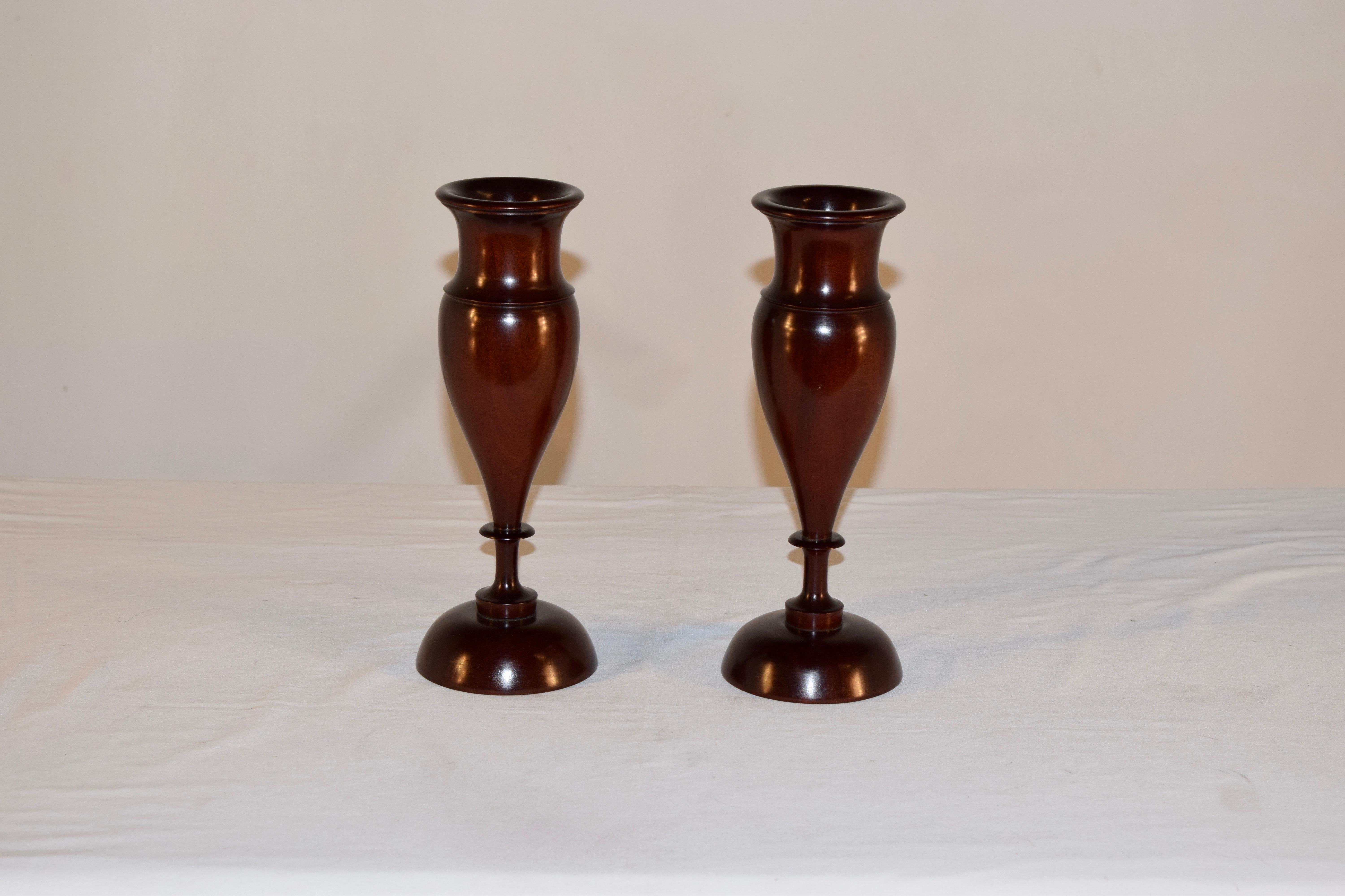Pair of lignum vitae vases from England circa 1900. They are gracefully hand turned and have a wonderful shape. The turned rims give way to shaped collars and bulbous bases, supported on hand turned dome bases.