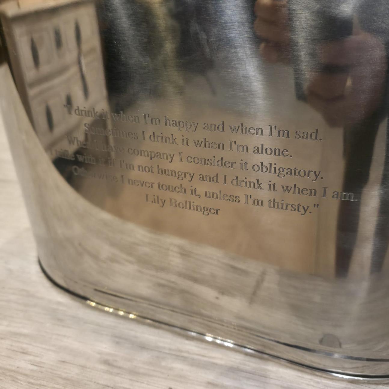 Pair of Napoleon Bonaparte stainless steel champagne buckets with 'Lily Bollinger' quotations.

The champagne bath bears the Napoleonic coat of arms and underneath a quote from Napoleon Bonaparte: 'I drink champagne when I win, to celebrate... and I