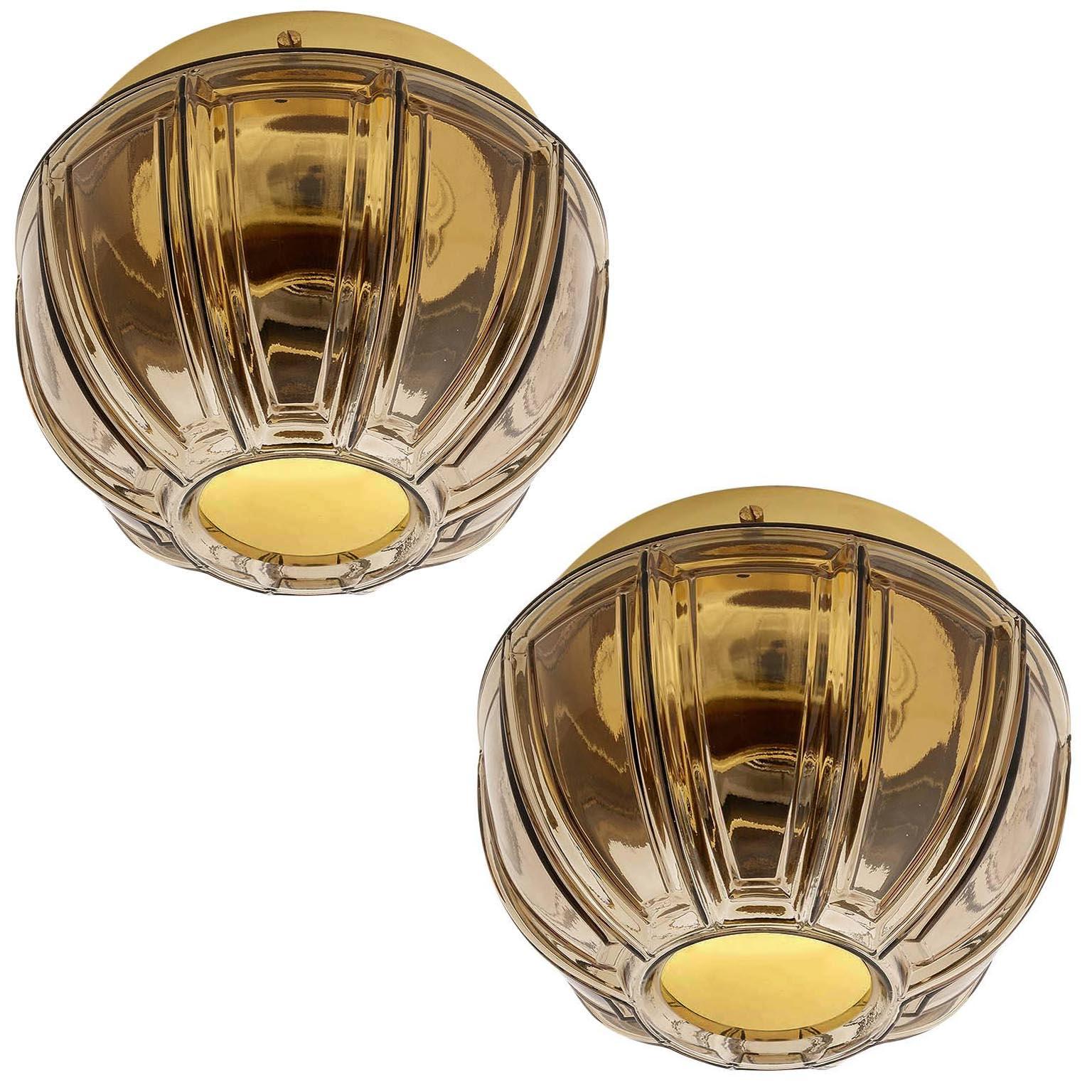 A pair of wall or flush mount lamps by Glashuette Limburg, Germany, manufactured in Mid-Century, circa 1970 (late 1960s or early 1970s).
A polished brass hardware with a smoke / amber / topaz / brown amethyst toned glass. Labeled with Glashütte