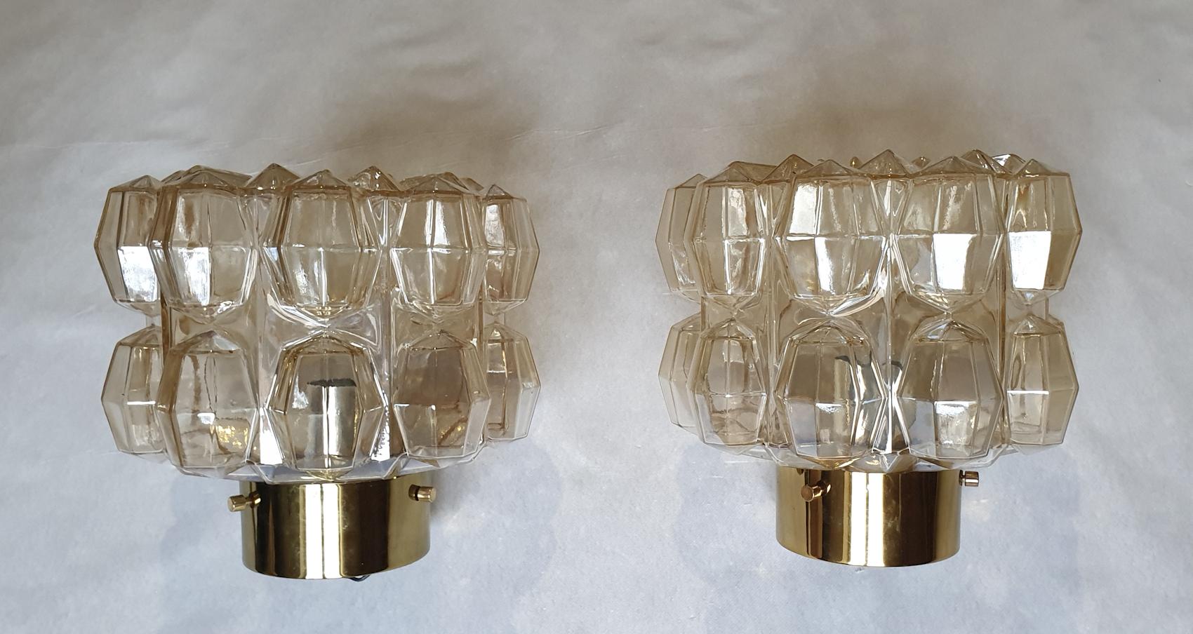 Pair of small stamped and signed Mid-Century Modern flush-mount lights or wall sconces, by Helena Tynell for Limburg.
Germany 1960s.
Made of sculpted beige/smoked Murano glass, and brass mounts.
1 light each, rewired for the US.
Creates a