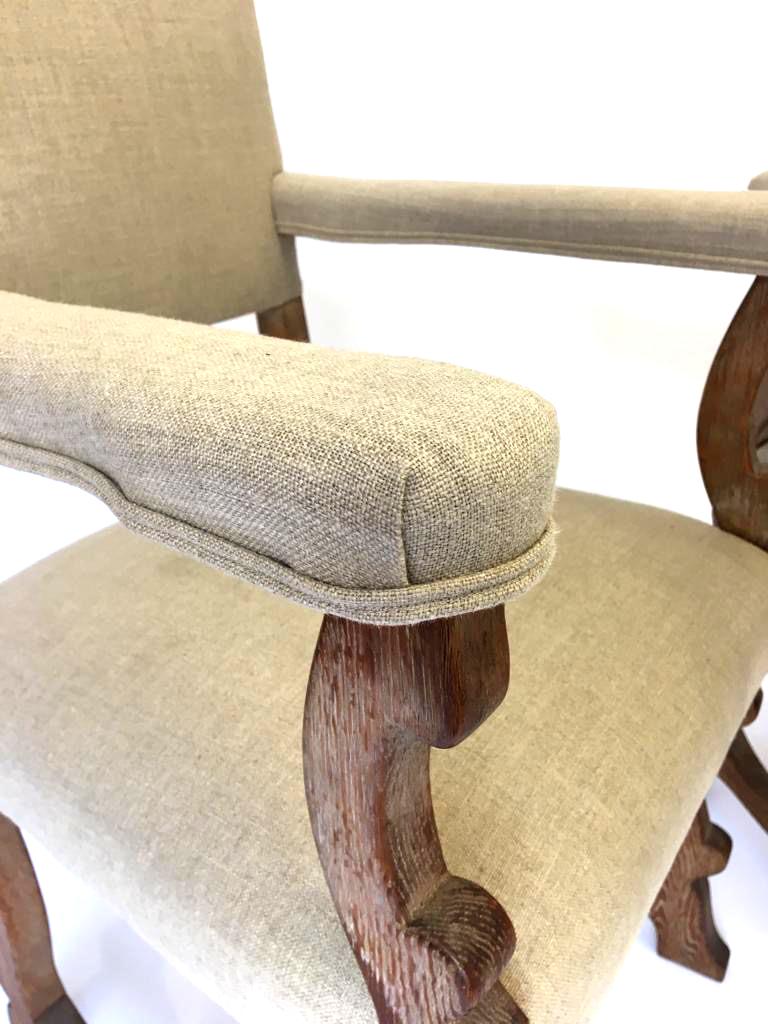 Pair of limed oak carver chairs upholstered in natural Belgian linen. Scottish Arts & Crafts, circa 1909, on a Tuscan base. These beautiful chairs are of compact size (the seat is narrow) perfect for an occasional, hall, side, bedroom