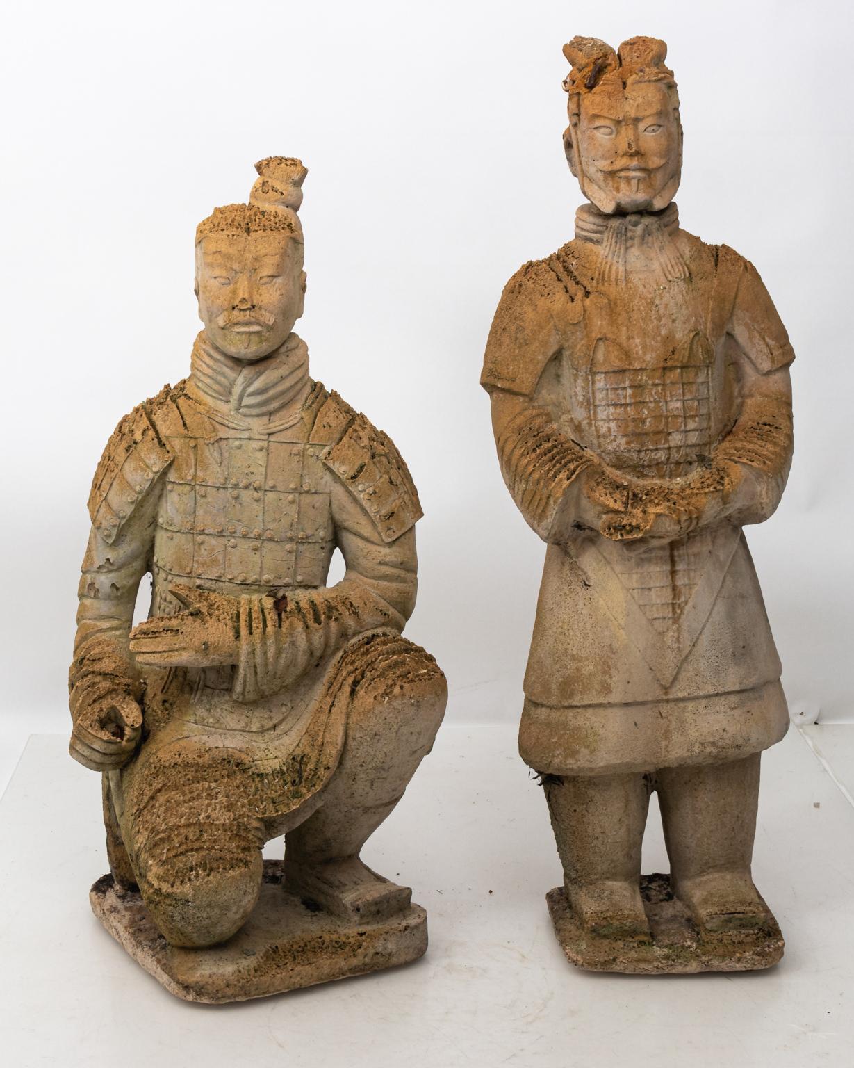 Pair of carved Limestone Japanese warrior statues in a weathered finish. Please note of wear consistent with age and exposure to the elements including loss to limestone and aged moss. The standing figure measures 42.00 inches height by 13.00 inches