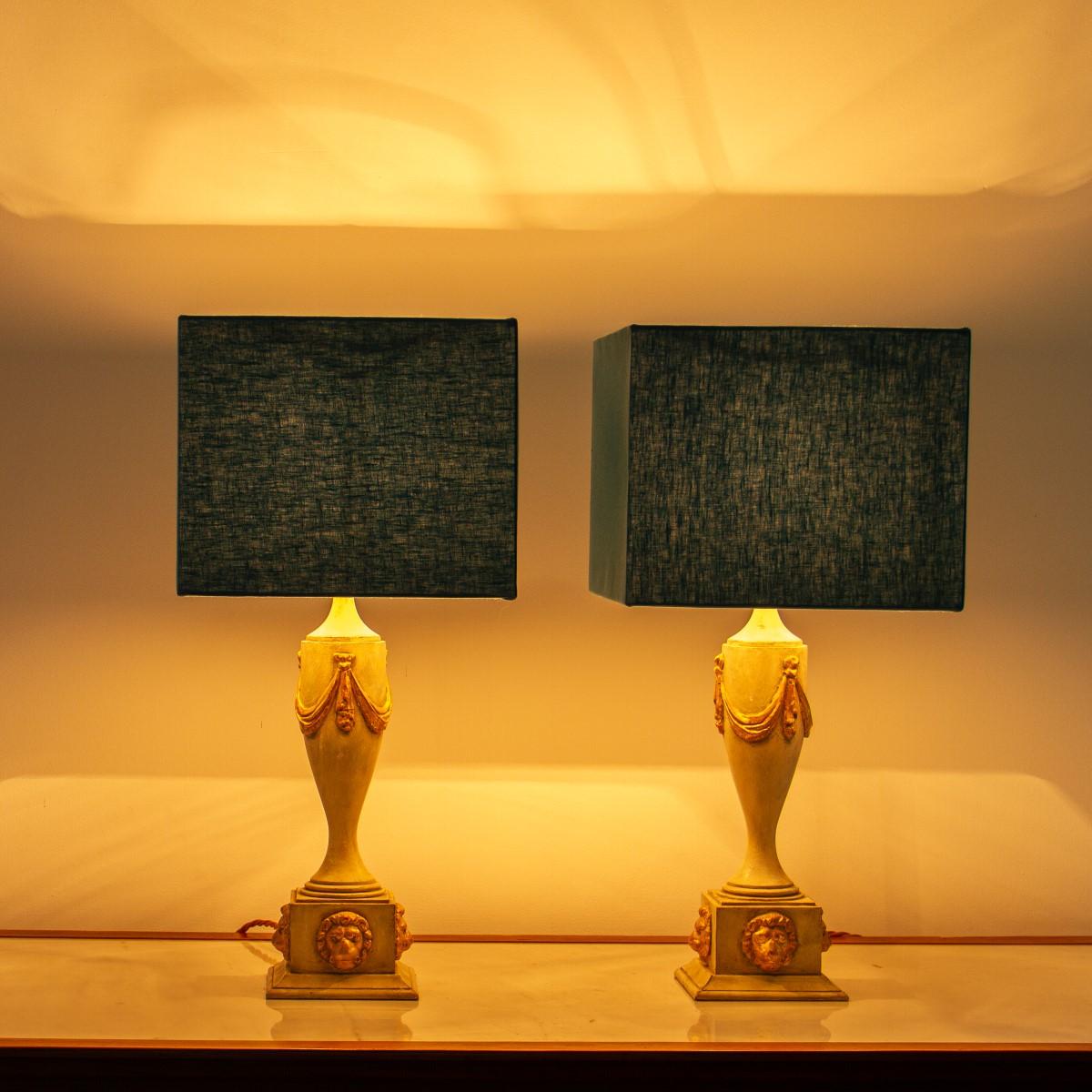 A pair of cream painted classical urn shaped lamps with gilt swag to the top of the urns and gilt lion masks to the socles, 1980s
Good vintage condition.