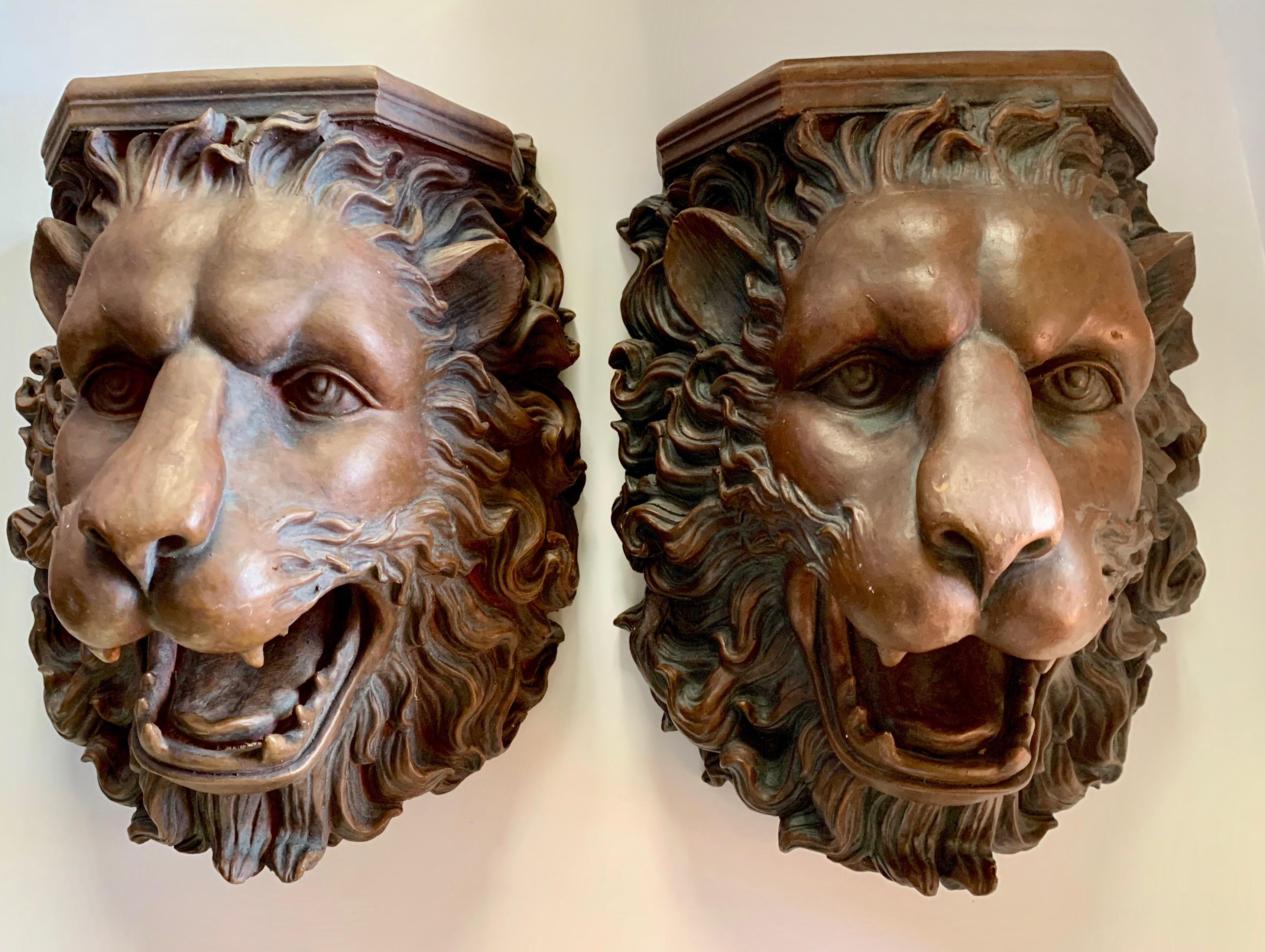 A monumental pair of lion wall shelves. A wonderfully detailed pair, with the look of wood, but a lighter material of resin or plastic. The pair have mounting holes in the rear for mounting. A handsome pair to flank a door or entry way... or create