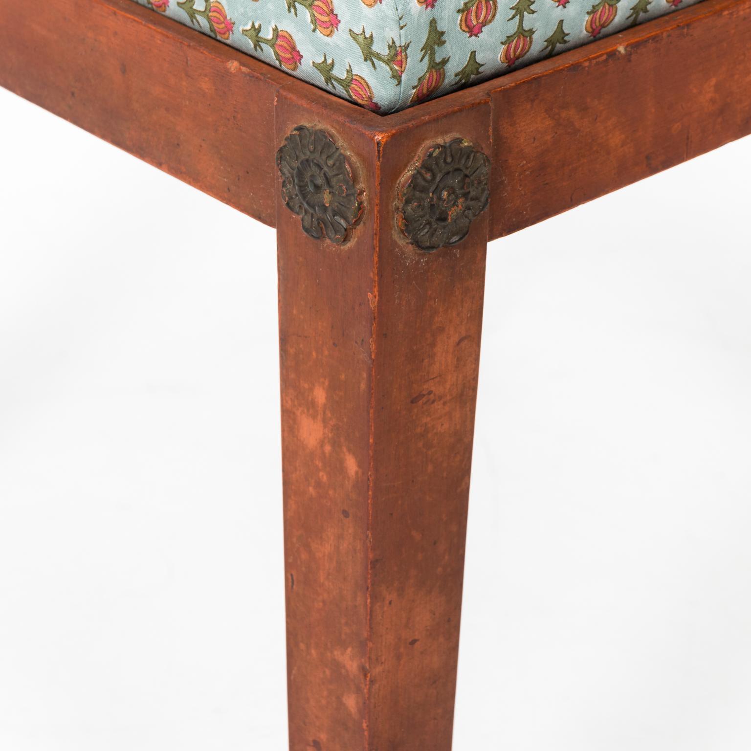 Floral upholstered benches with Lion's paw feet and painted legs, circa 20th century. Please note of wear consistent with age including oxidation to brass feet.
 