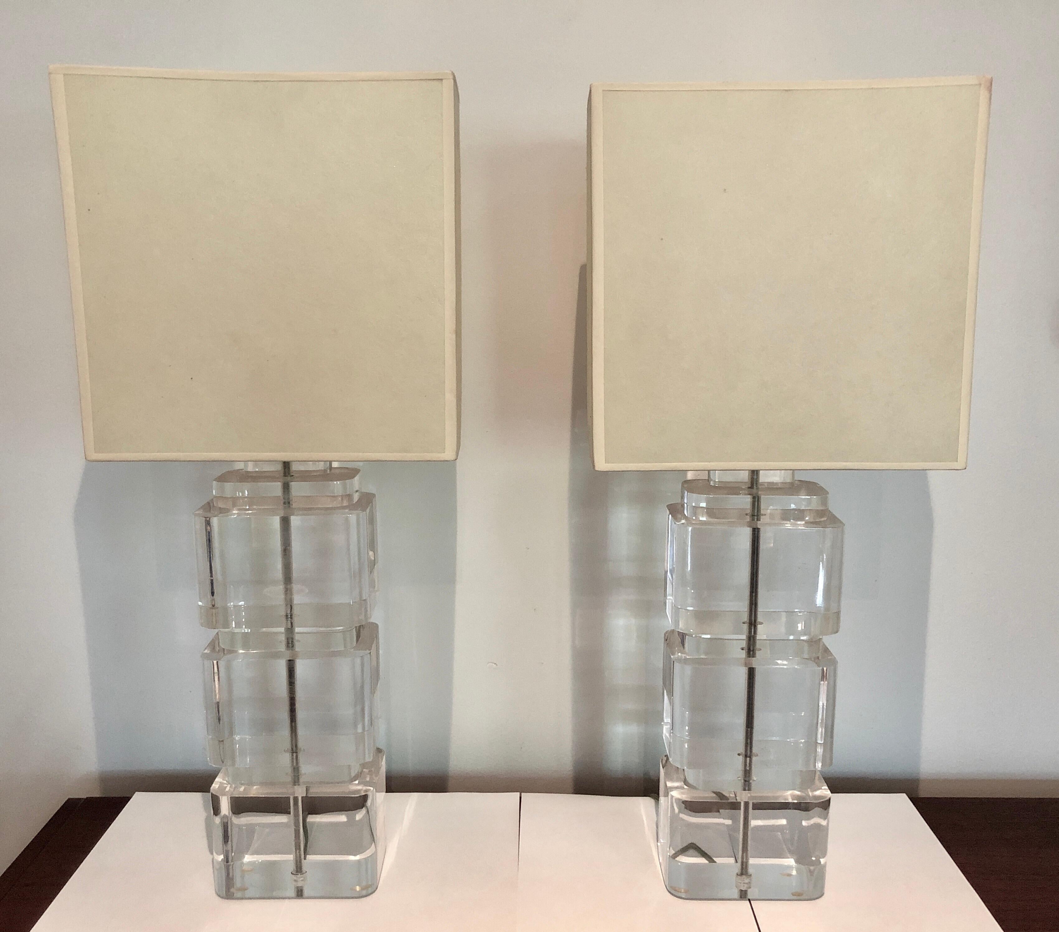 Two large Lucite column table lamps composed of three stacked rectangular blocks with nickel fittings and original parchment shades, circa 1970s.