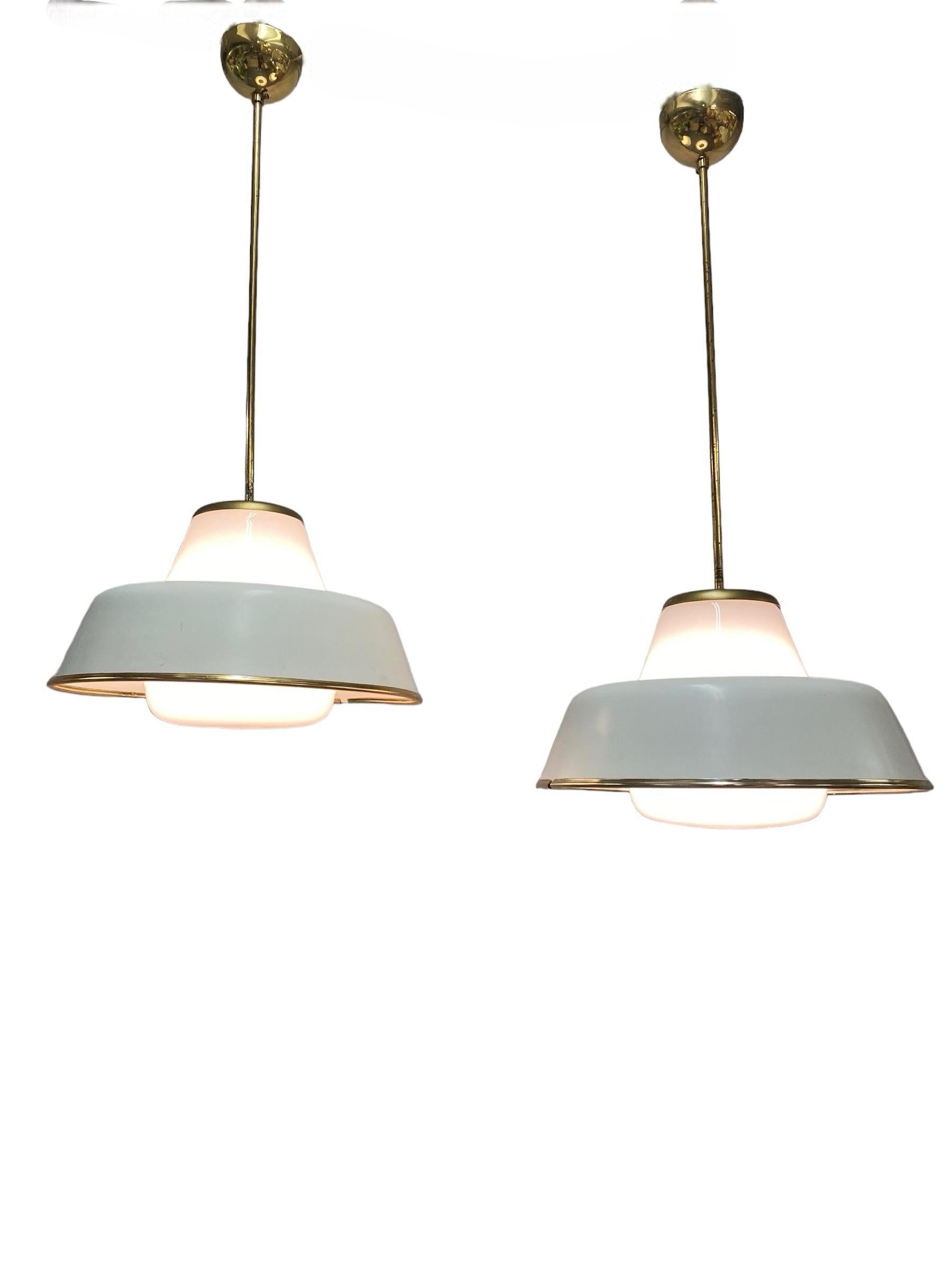 Impressive original pair of Lisa Johansson-Pape ceiling pendants model 61-347, manufactured by Orno in Finland in the 1950s. This UFO like shaped lamp was quite popular back then, and still is now. It's found in both public buildings and private