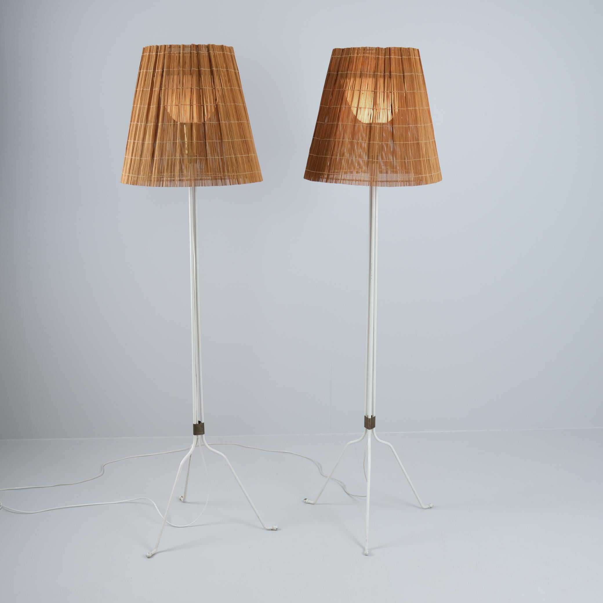A beautiful pair of Lisa Johansson-Pape floor lamps model 30-058 in painted metal, brass and copper details with acryilic and rattan shade. This floor lamp is a more rare modified design on the ihanne floor lamp that became very popular in Finland