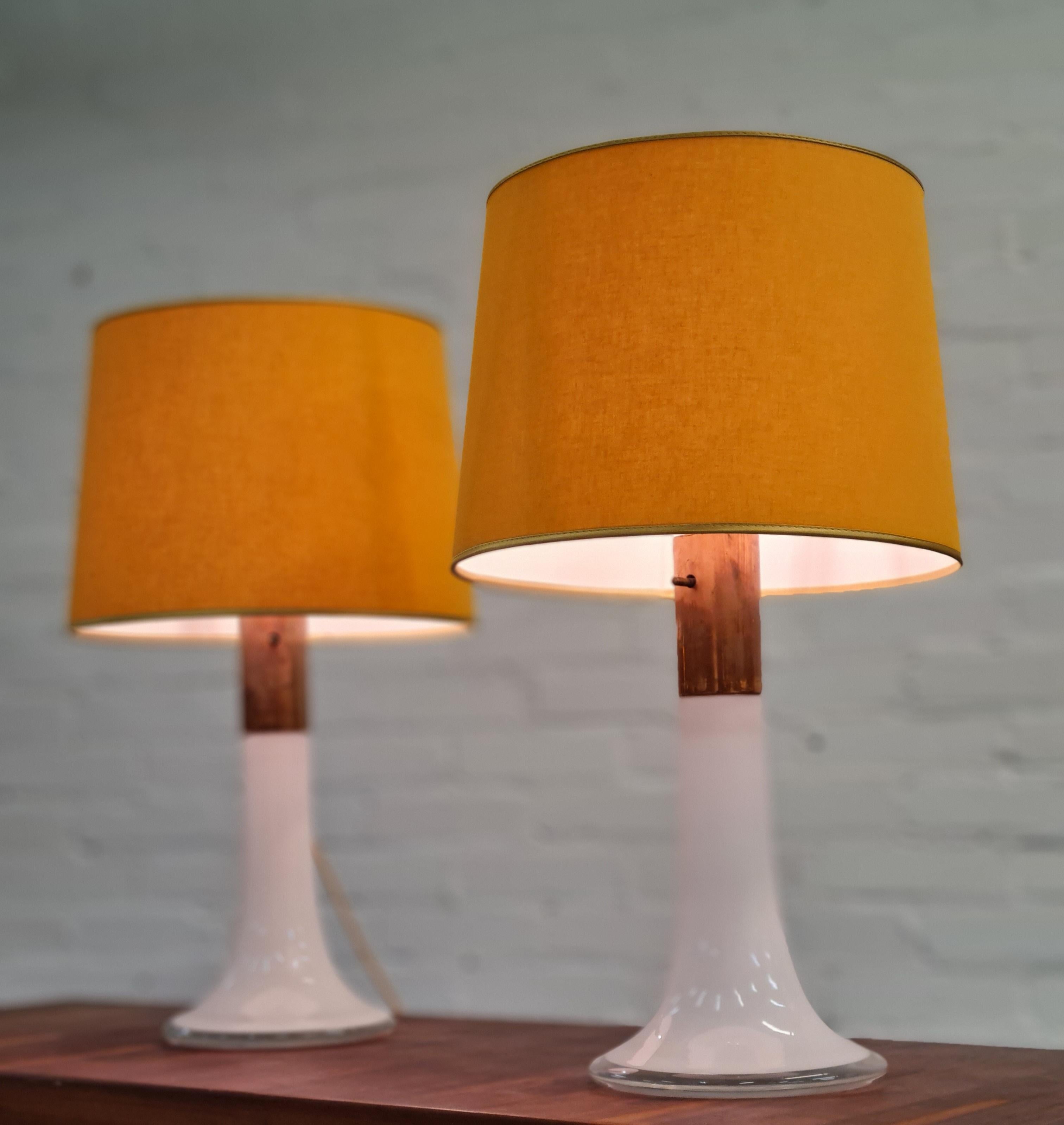 A beautiful pair of table lamps in original condition with a beautiful patina and shades redone on original shade frames and a similar fabric as the original. Designed by the renowned Lisa Johansson-Pape this model is one of the most recognized