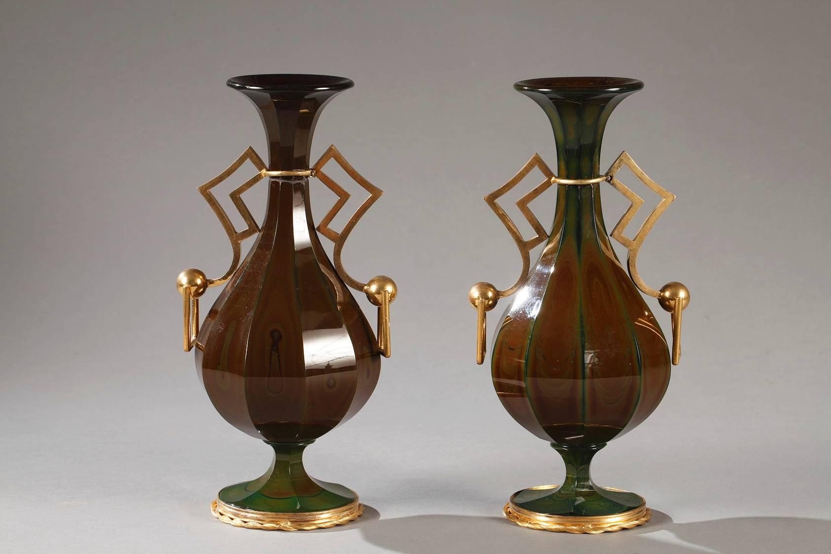 Rare pair of vases in Bohemian lithyalin glass featuring angled sections and gilt bronze mounts. Each of the dark green and marbled vases rests on a pedestal base encircled by a gilt bronze spiraling ribbon. The simple yet elegant angular handles