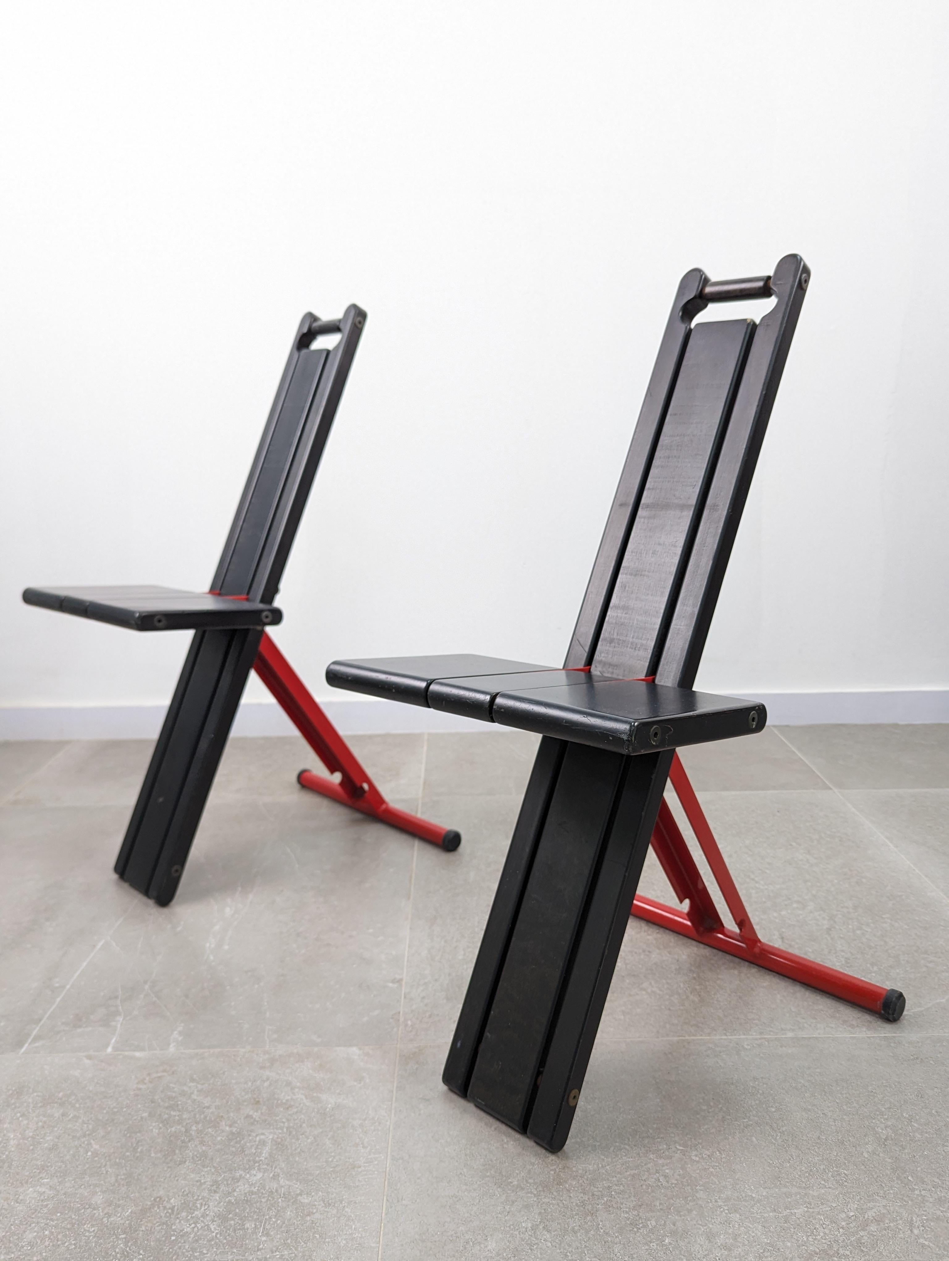 Paire de chaises pliantes portables conçues en 1982 par Torstein Nilsen initialement pour Kalvatn Møbelindustri et produites en 1984 par Møremøbler AS, en hêtre laqué noir, avec des éléments de support en fer laqué rouge. En outre, cette conception