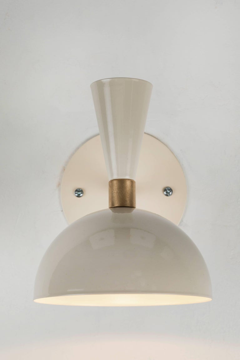 Pair of 'Lola' brass and metal adjustable sconces in Ivory. Hand-fabricated by Los Angeles based designer and lighting professional Alvaro Benitez, these highly refined sconces are reminiscent of the iconic midcentury Italian designs of Arteluce and