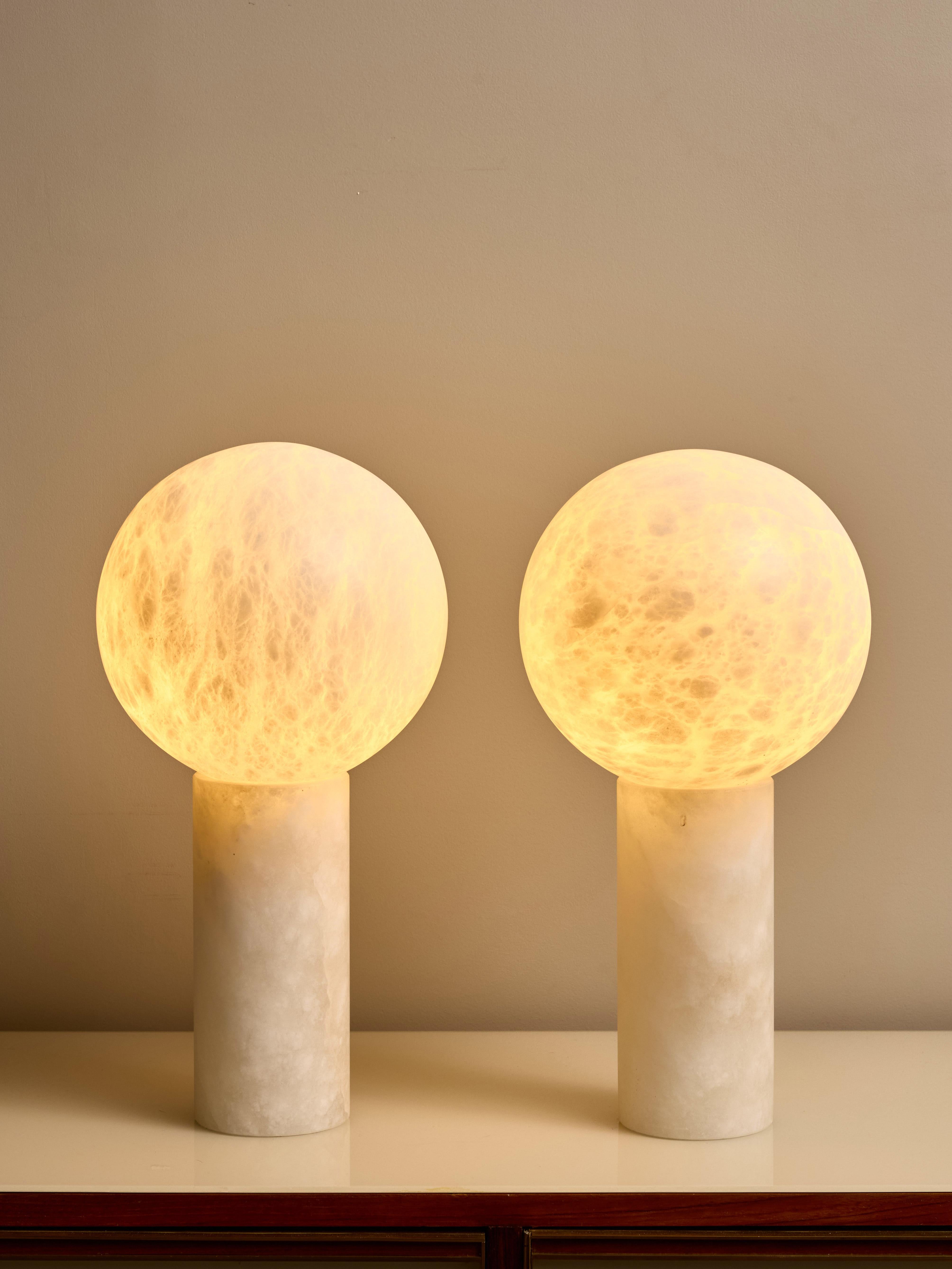 Ensemble de lampes de table en albâtre dont la base cylindrique est surmontée d'un globe qui abrite une seule source lumineuse.