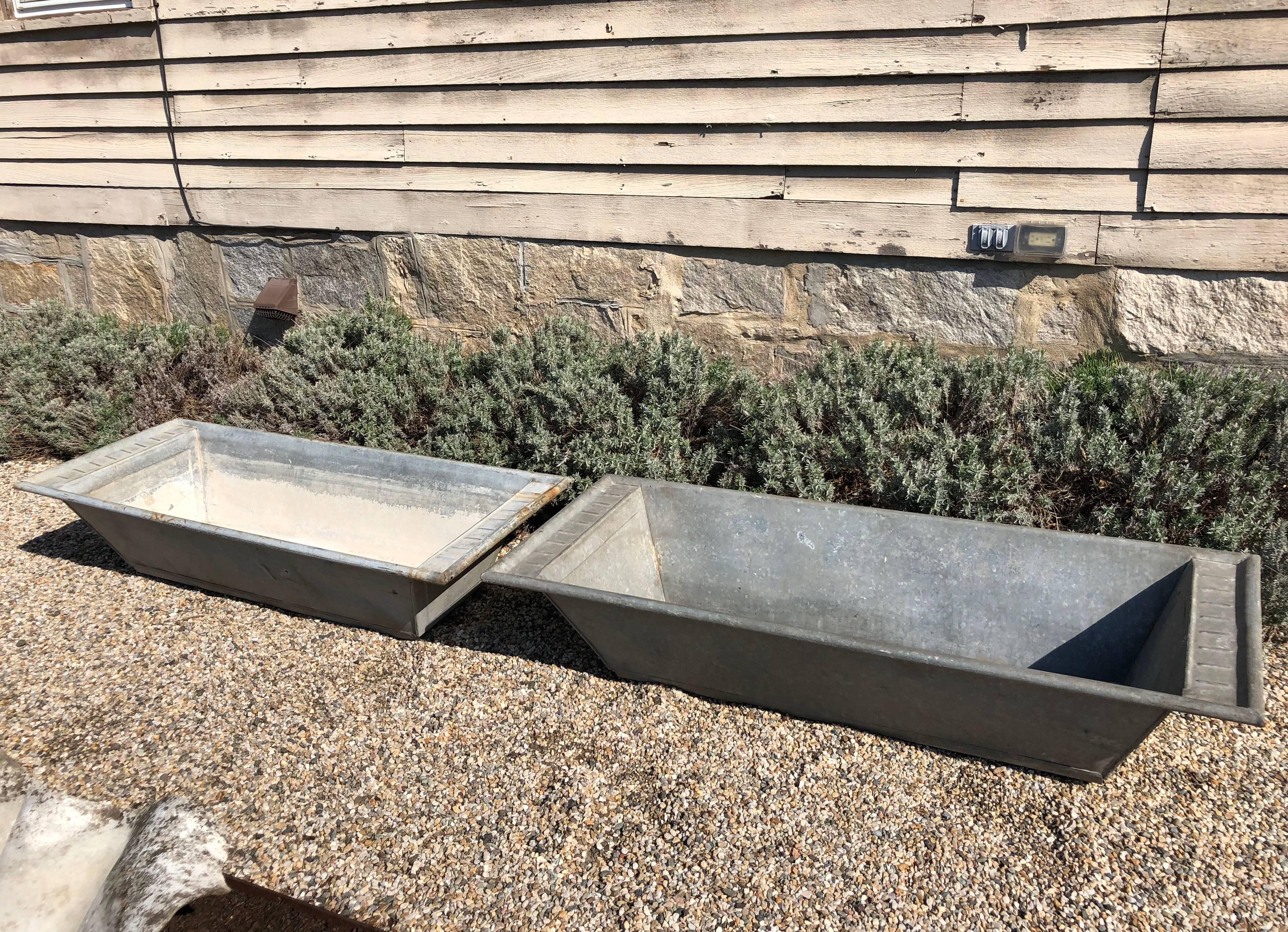 The clean industrial look of these troughs is softened by the ribbed decoration on each end and each sports four small v-shaped feet to raise them slightly off the ground. They would make an eye-catching display on a terrace or flanking a large