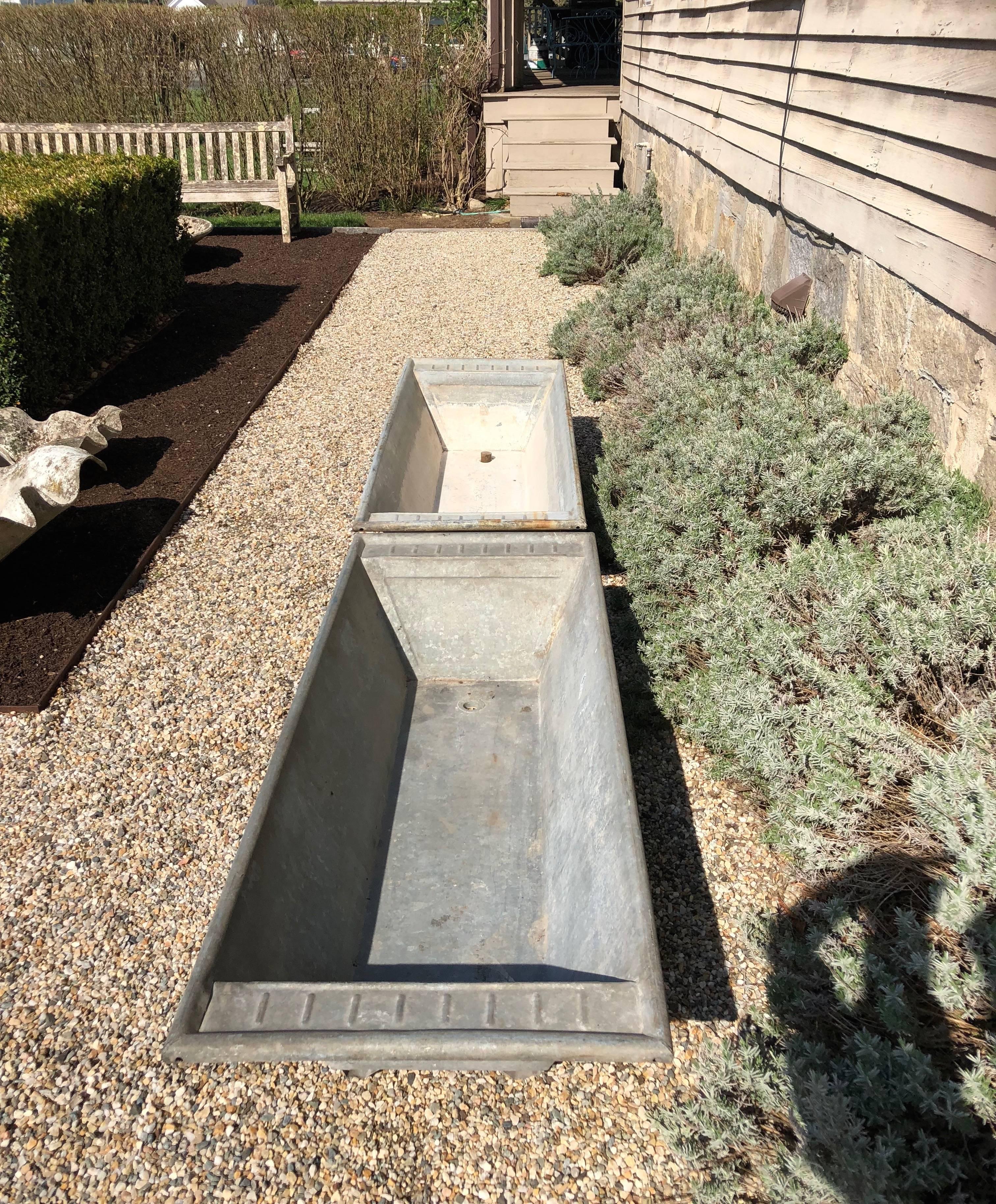 The clean industrial look of these troughs is softened by the ribbed decoration on each end and each sports 4 small v-shaped feet to raise them slightly off the ground. They would make an eye-catching display on a terrace or flanking a large doorway