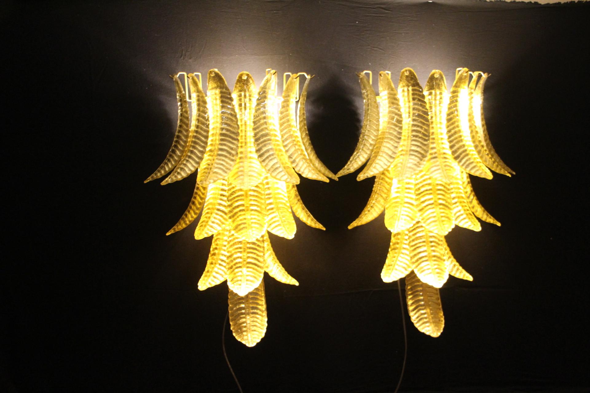 This spectacular pair of long wall lights was entirely handcrafted in Murano. Each single leaf was individually made in high quality blown glass, this is why we can notice very light difference from a piece to another. Its gold color was made thanks