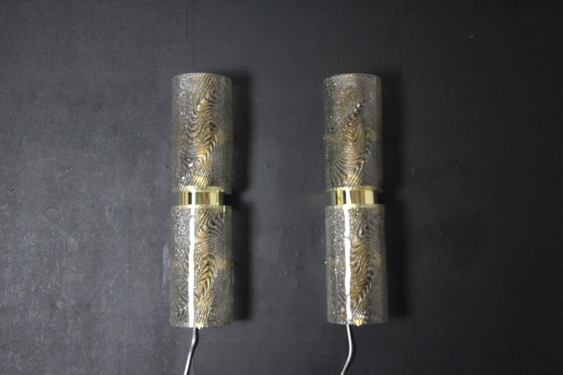 This wonderful pair of glass sconces features frosted graniglia Murano glass in smoked color and brass. The graniglia technique is a Murano speciality to get this so special look. Moreover,these sconces have a very unusual design. They've got