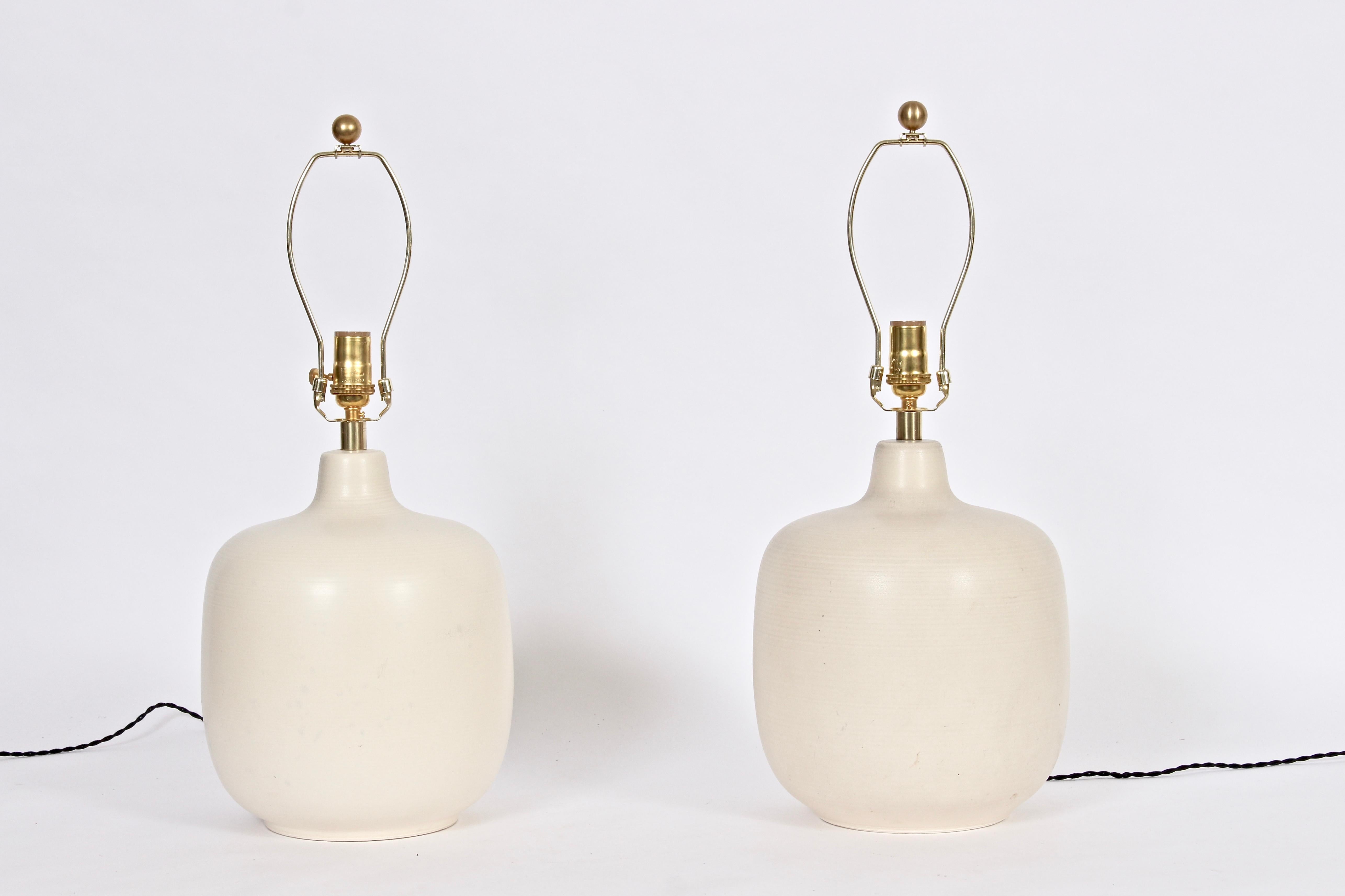 Pair of Lotte & Gunnar Bostlund larger stoneware table lamps in bone glaze, circa 1960. With light circular texture. Shades shown for display only (10H x 13D top x 15D bottom). 16 H to top of socket. Classic. Fine design.  Made in Canada.  Priced
