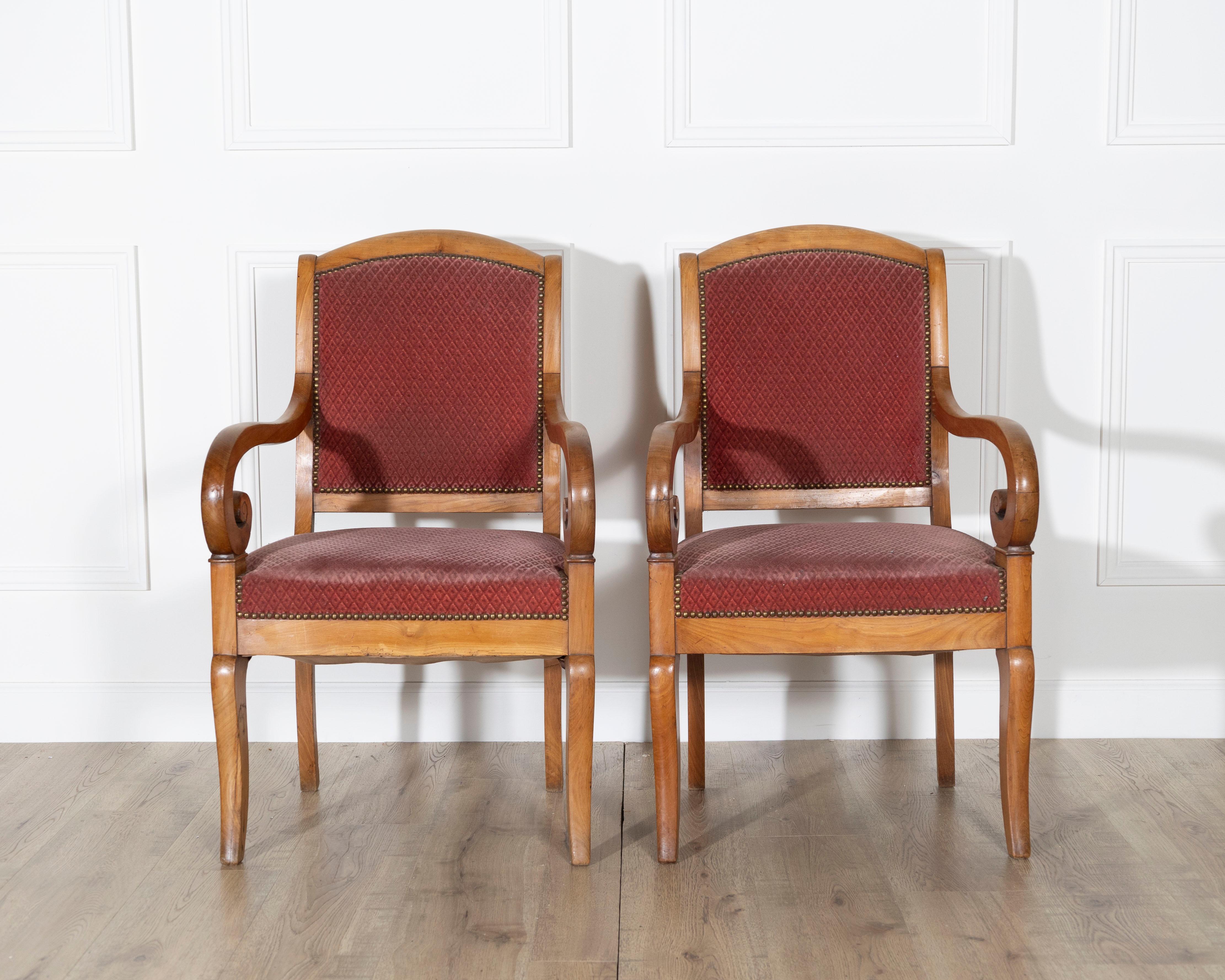 Questa elegante coppia di poltrone Louis Philippe incarna la raffinata semplicità e le proporzioni equilibrate del design francese della metà del XIX secolo. Realizzate in caldo legno di ciliegio, le cornici mostrano linee aggraziate e fluide e