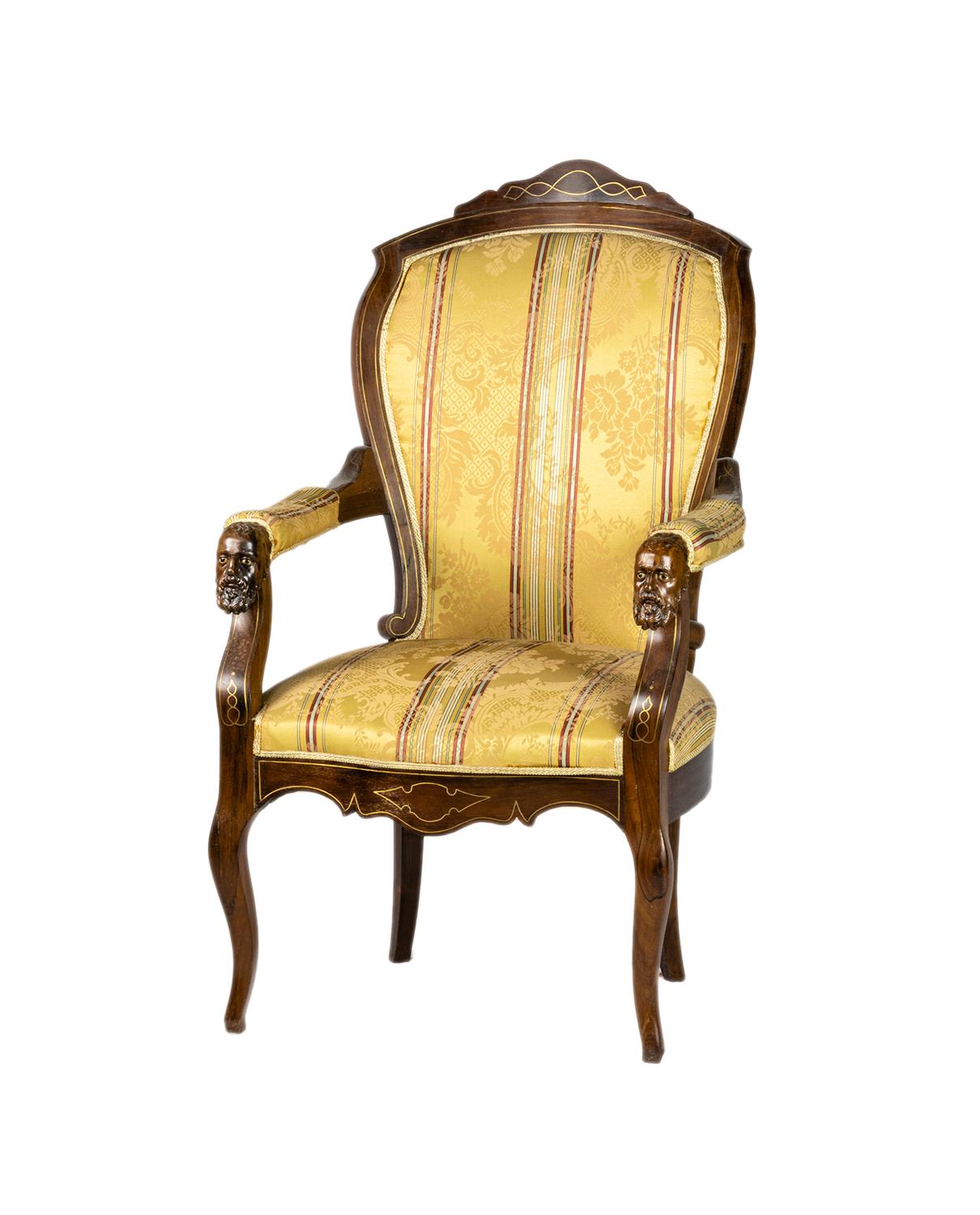 A pair of Louis Philippe Voltaire armchairs, crafted in the 19th century, in great condition. 

Each piece features richly carved armrests showcasing bearded male faces in an Orientalist style, a unique artistic detail rarely seen. The chairs are