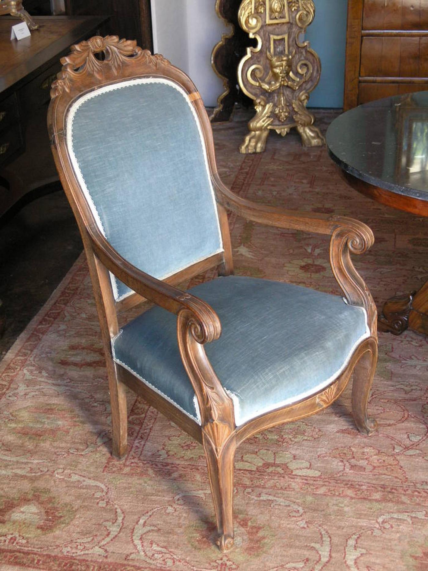 Pair of Louis Philippe carved walnut arm chairs. The upholstered panel back with foliate cresting above arm supports and upholstered panel seats on cabriolet legs.