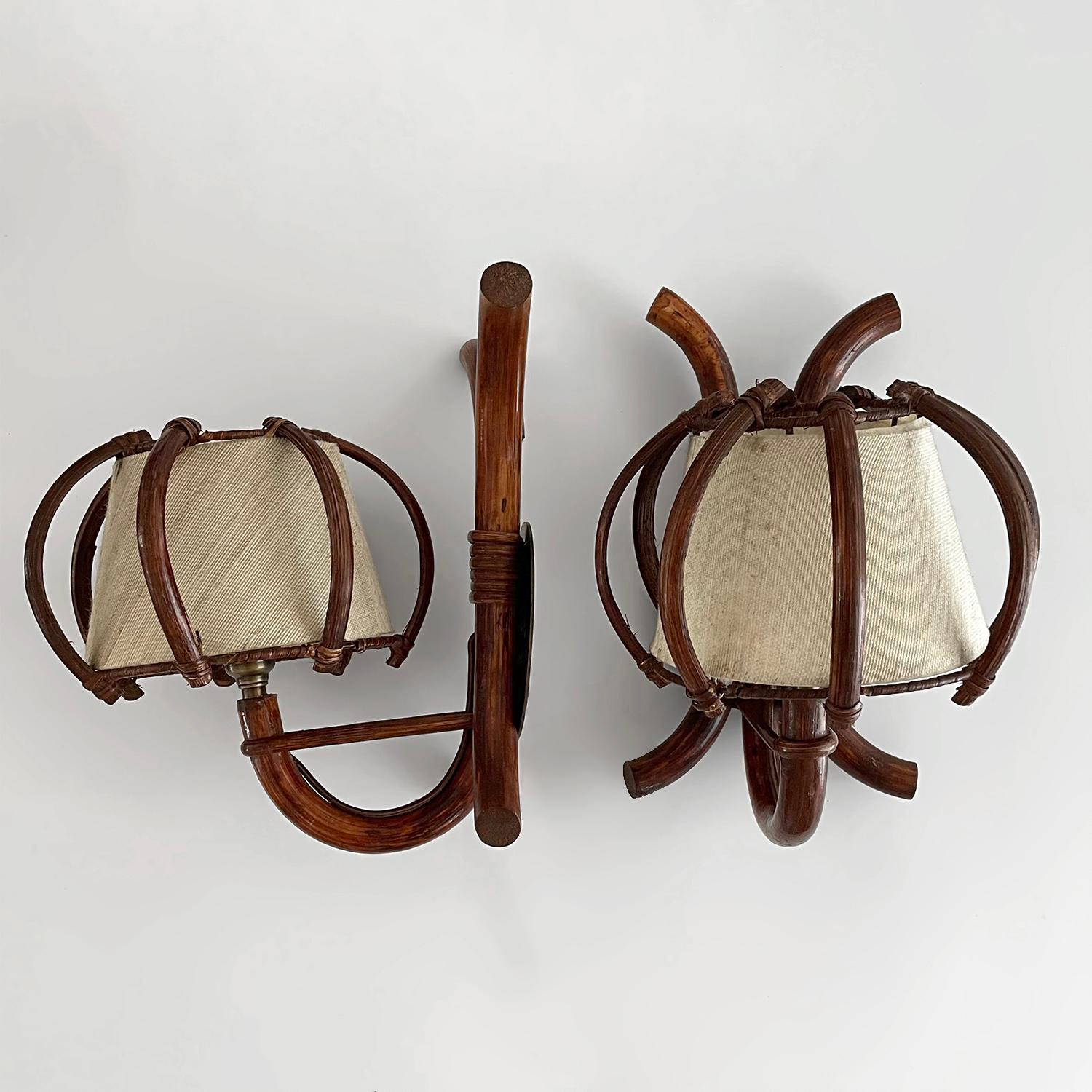 Pair of Louis Sognot arched bamboo sconces
France, circa 1960s
Each lamp is unique in its organic composition and feel 
Sculpted bamboo wall mounted backpiece includes new aged brass backplates
Beautifully sculpted bamboo arches are the centerpiece
