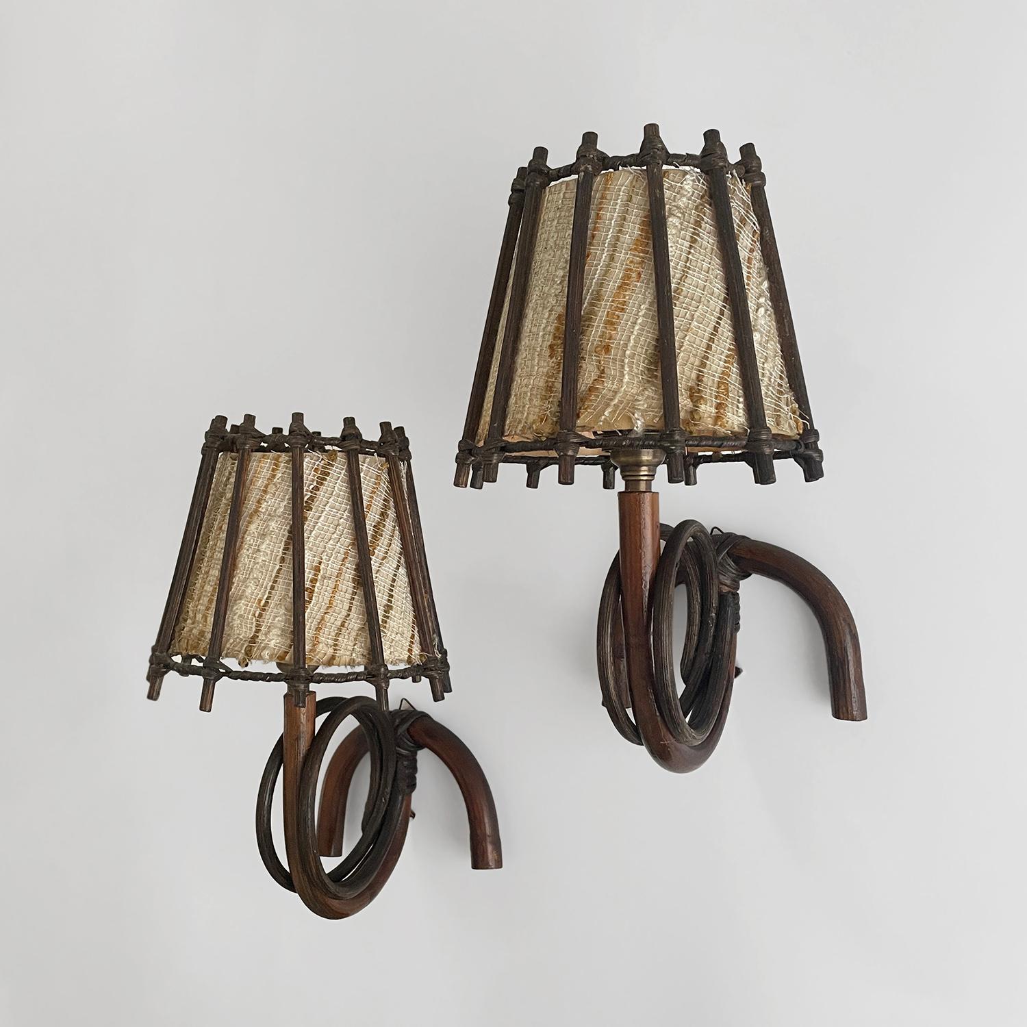Pair of Louis Sognot bamboo & rattan sconces
France, circa 1960s
Each lamp is unique in its organic composition and feel 
Sculpted bamboo wall mounted backpiece is accented with looped rattan details and has a single mounting loop
Ascending arm