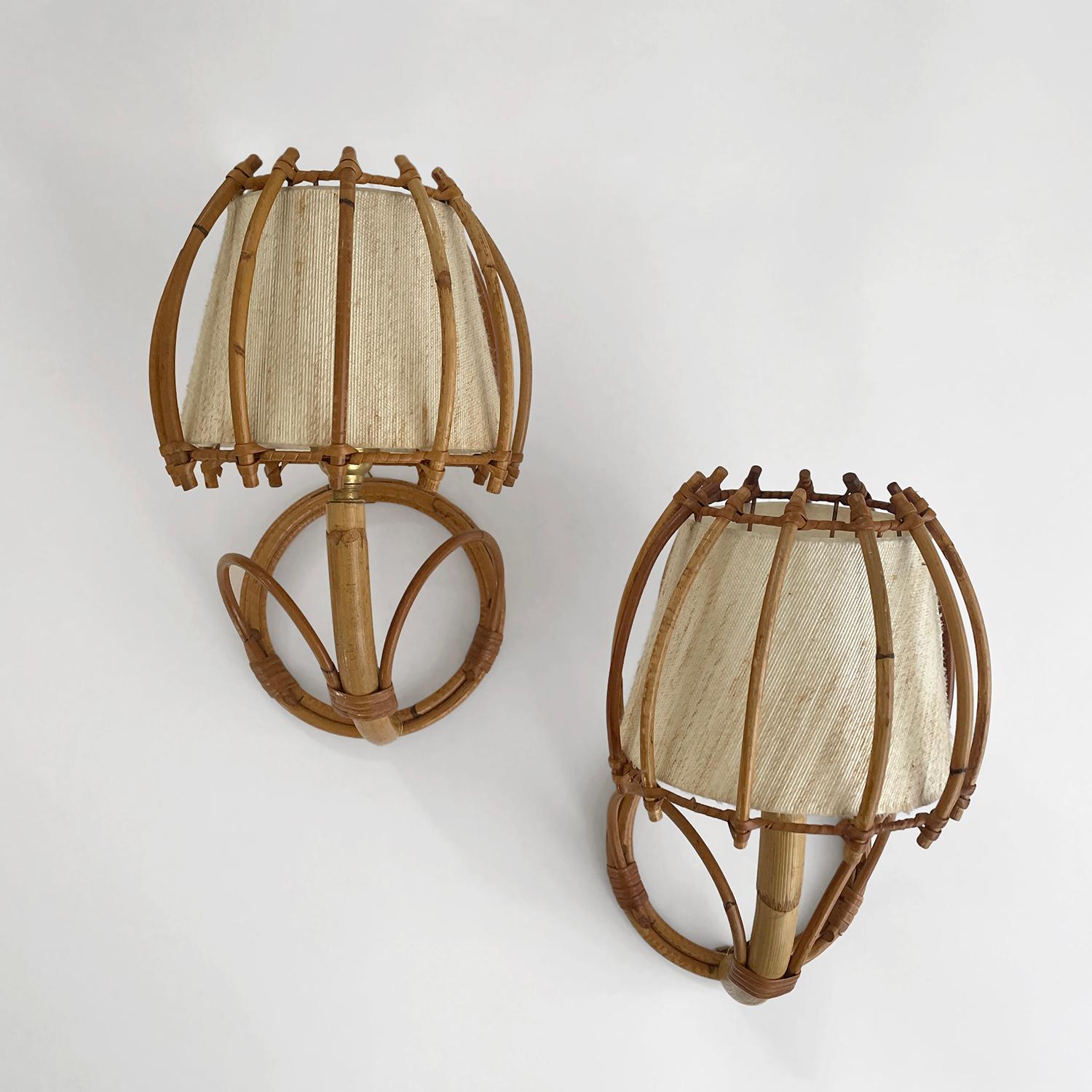 Pair of Louis Sognot rattan lantern sconces
France, circa 1960s
Each lamp is unique in its organic composition and feel 
Sculpted circular rattan wall mounted backpiece is accented with looped details and has a single mounting loop
Ascending arm